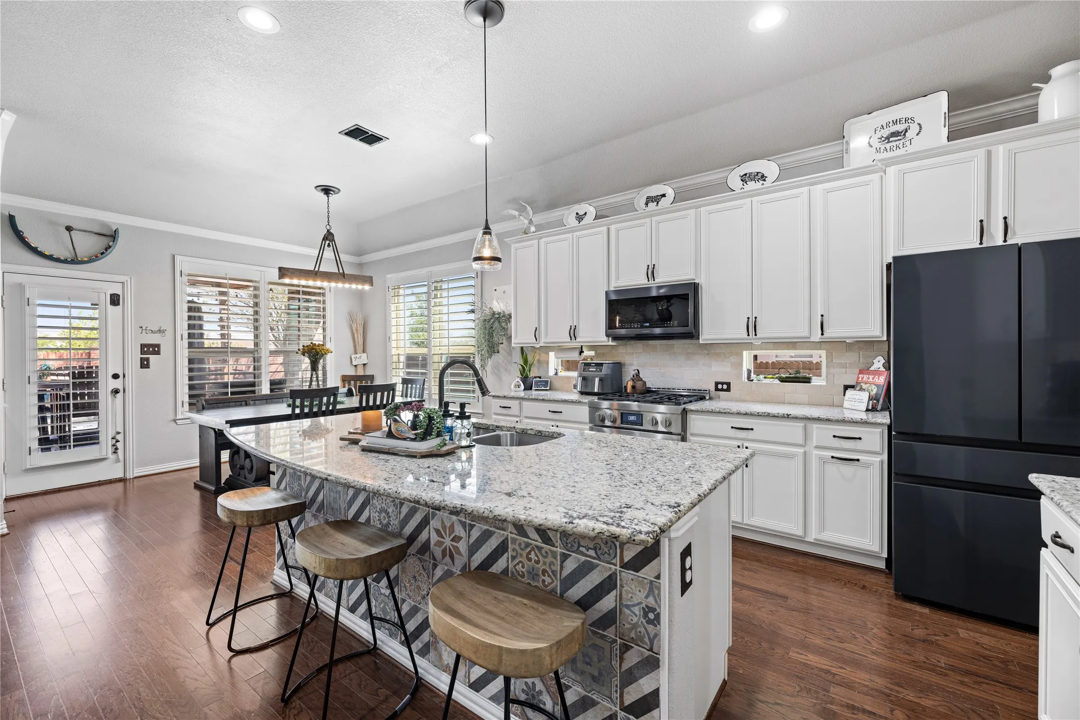 Kitchen with a healthy amount of sunlight, pendant lighting, stainless steel appliances, and dark hardwood / wood-style floors