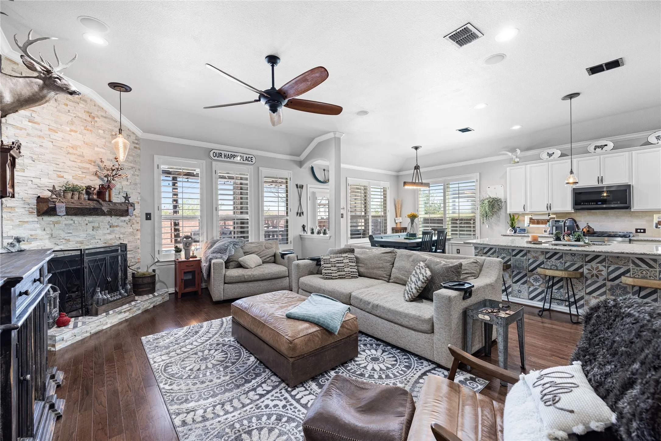 Living room featuring ornamental molding, ceiling fan, a wealth of natural light, and dark hardwood / wood-style floors