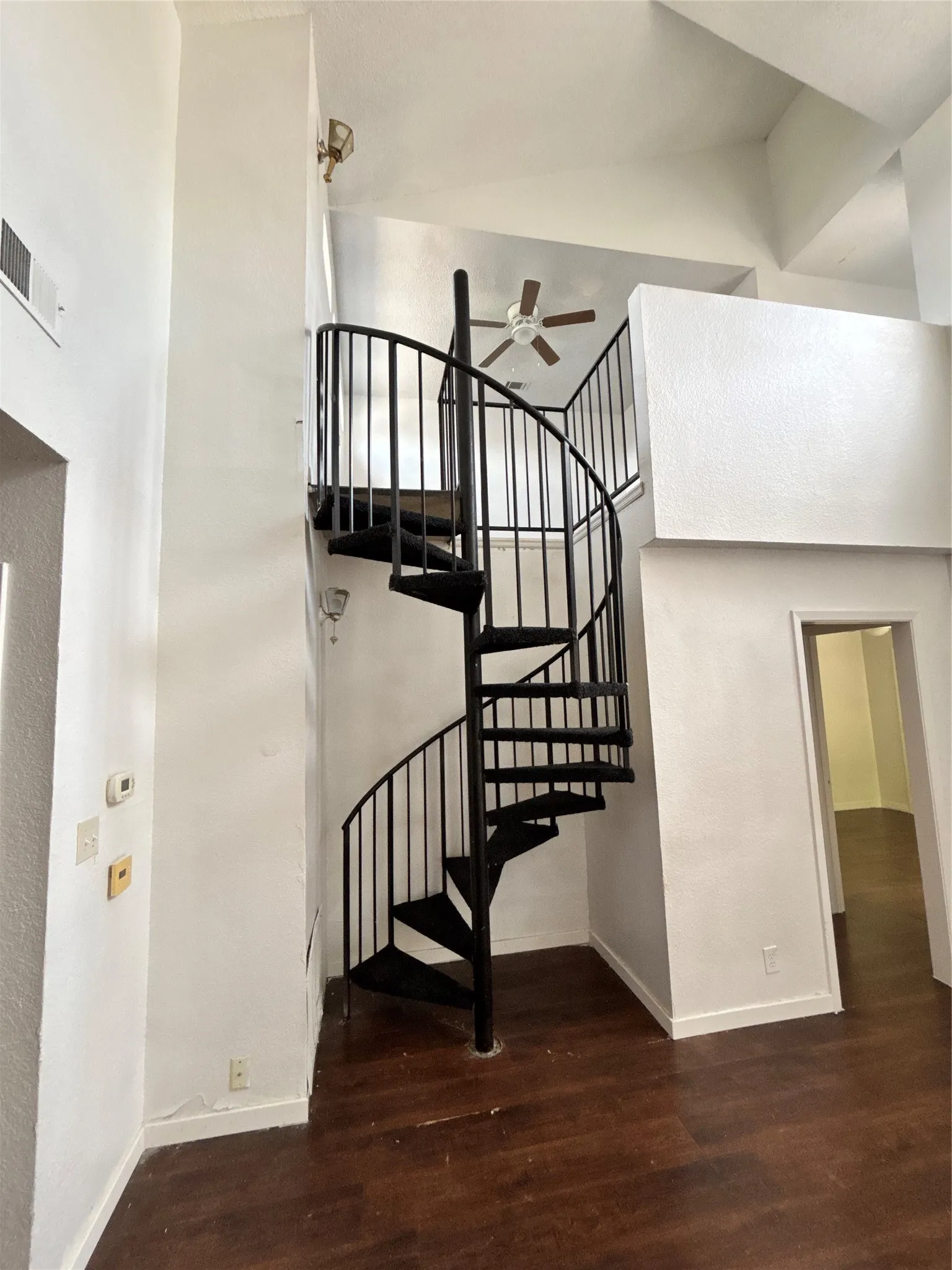 Black metal spiral staircase with wood-finish treads
