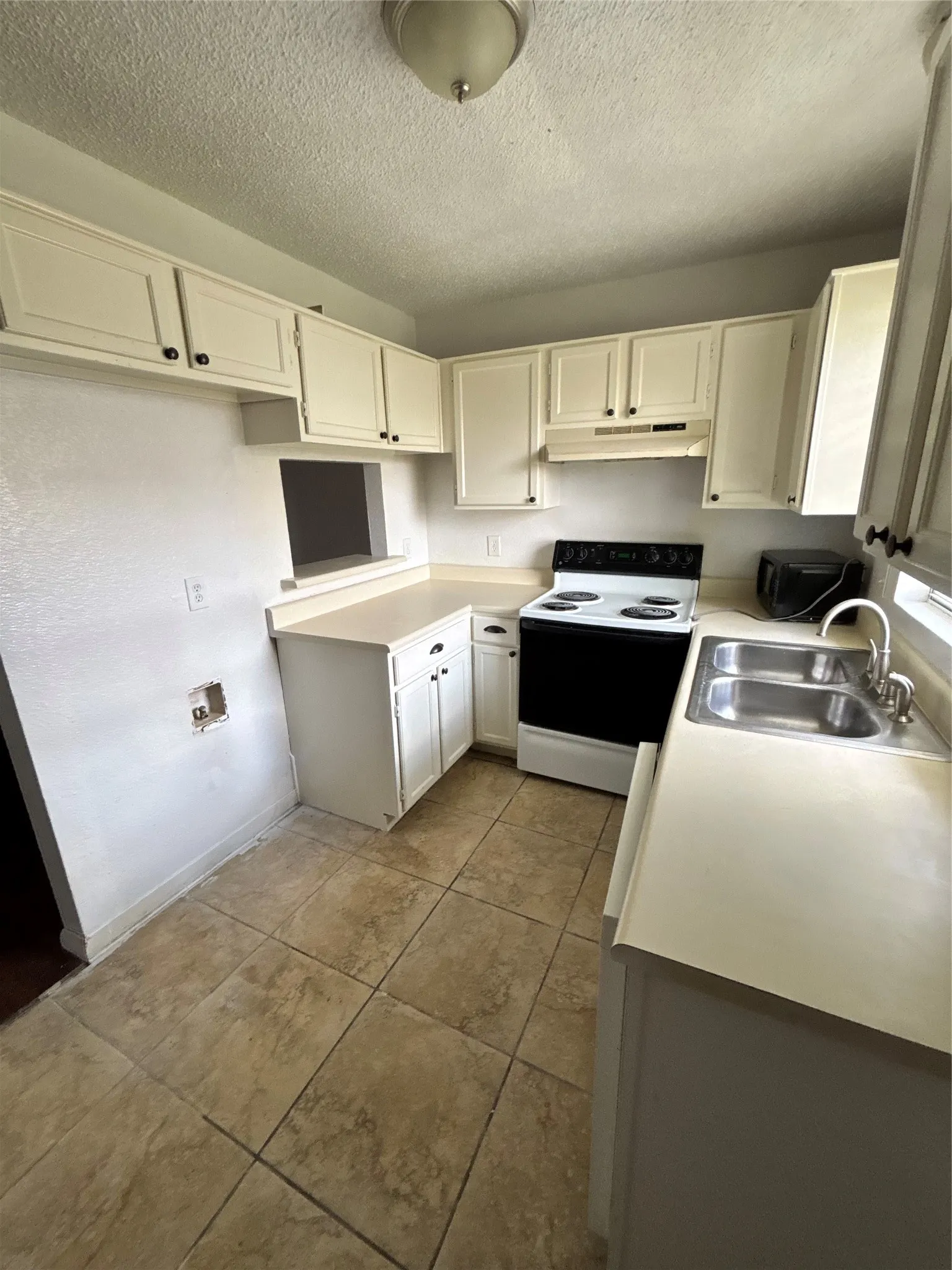 Well-appointed kitchen featuring white cabinetry and light-toned countertops