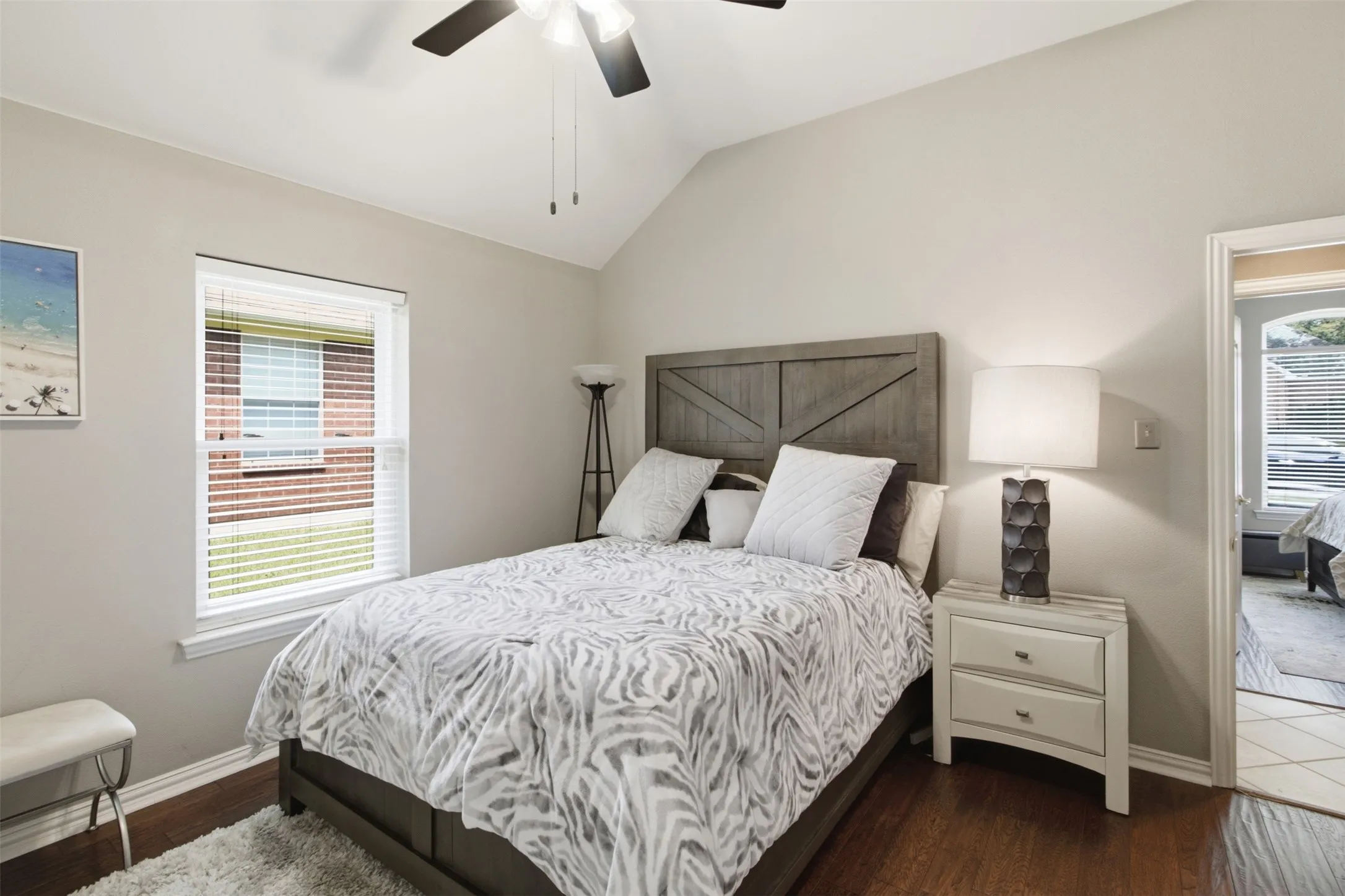 Spacious bedroom featuring vaulted ceilings, a ceiling fan, and wood-finish flooring