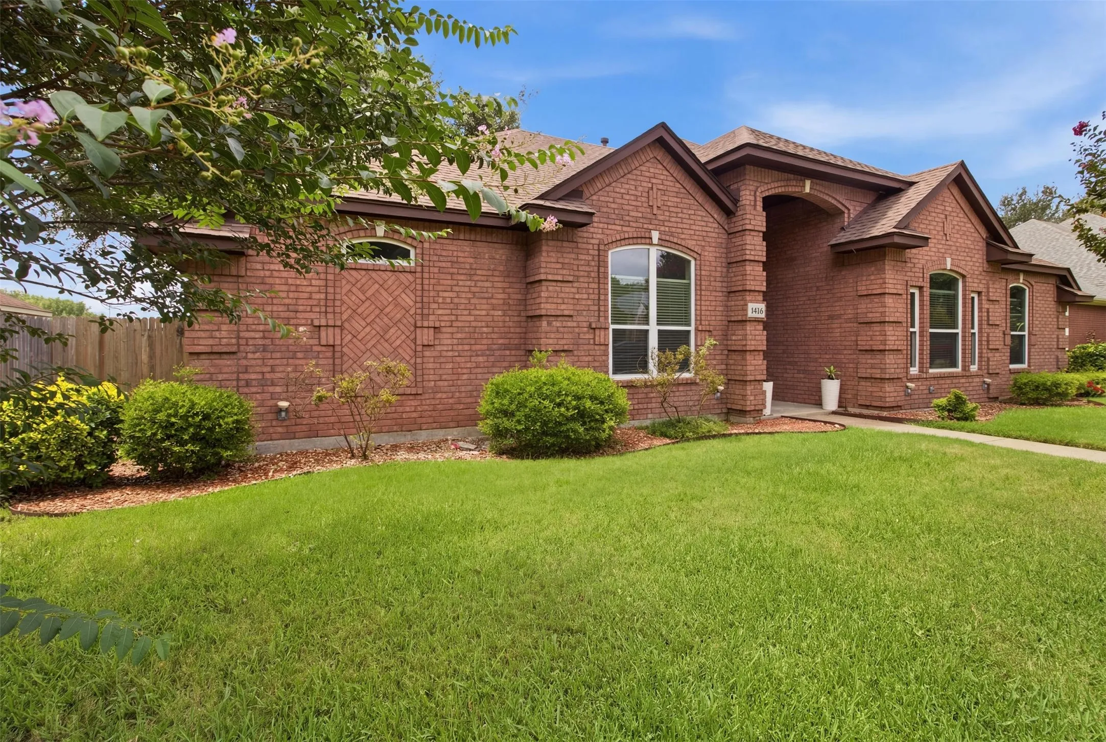 Brick exterior featuring an arched entryway and multiple arched windows