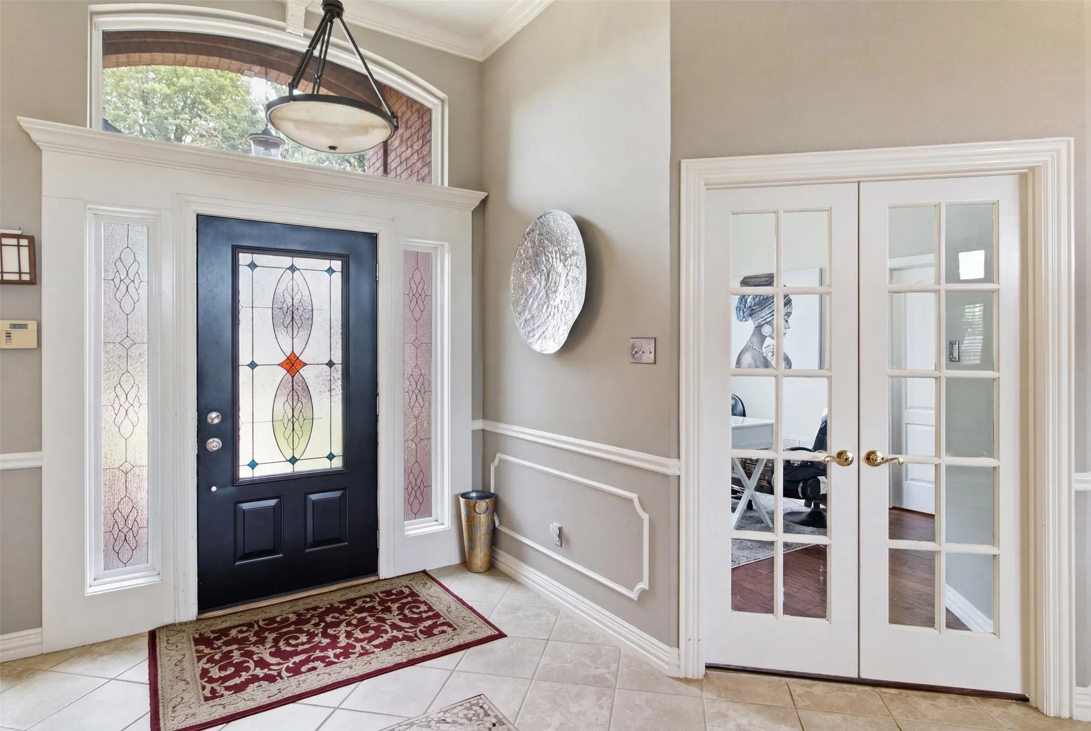 Entry foyer featuring a transom window, decorative sidelights, and a black front door with stained glass