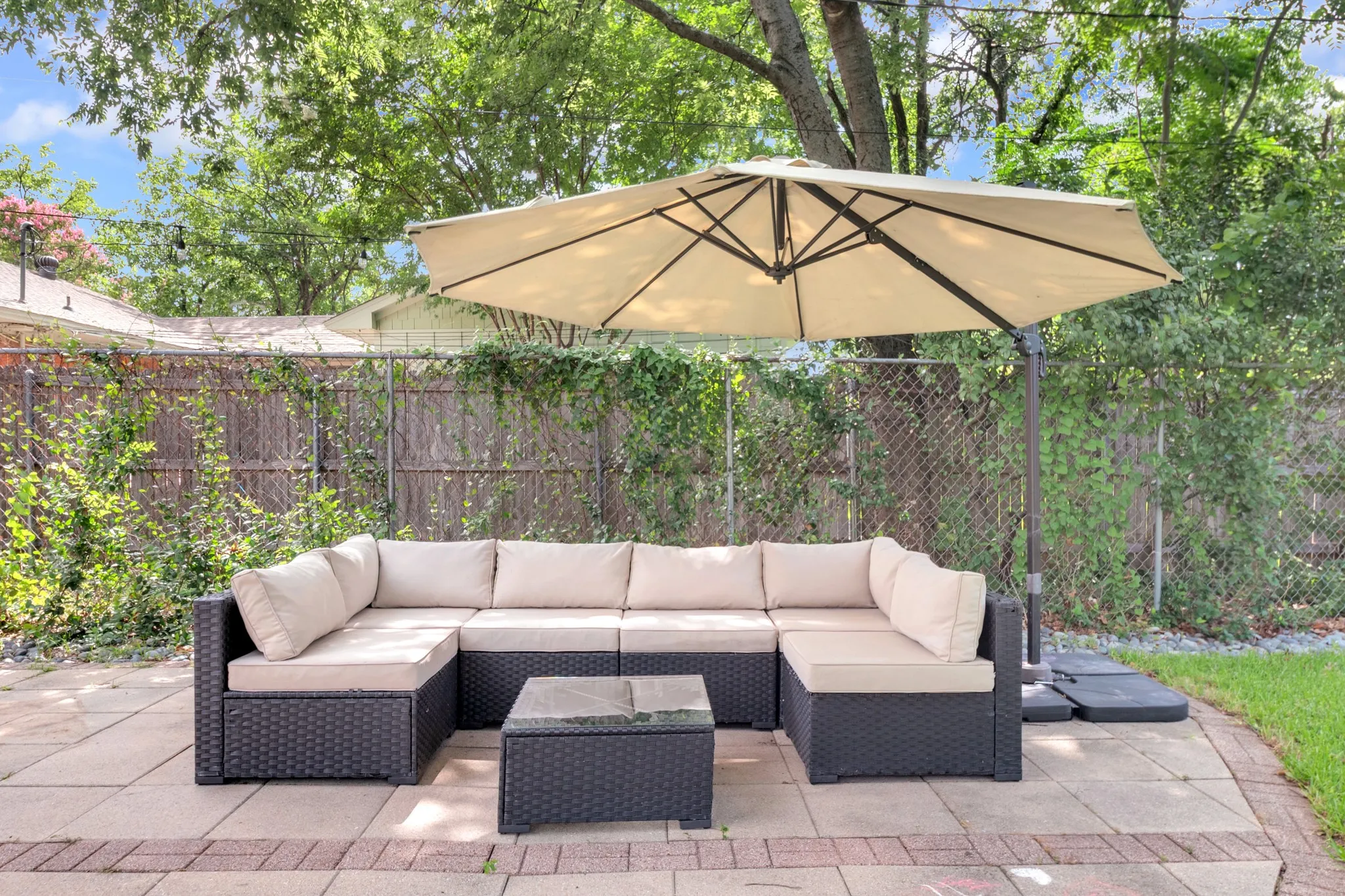 Paved patio area featuring large format pavers and a brick border