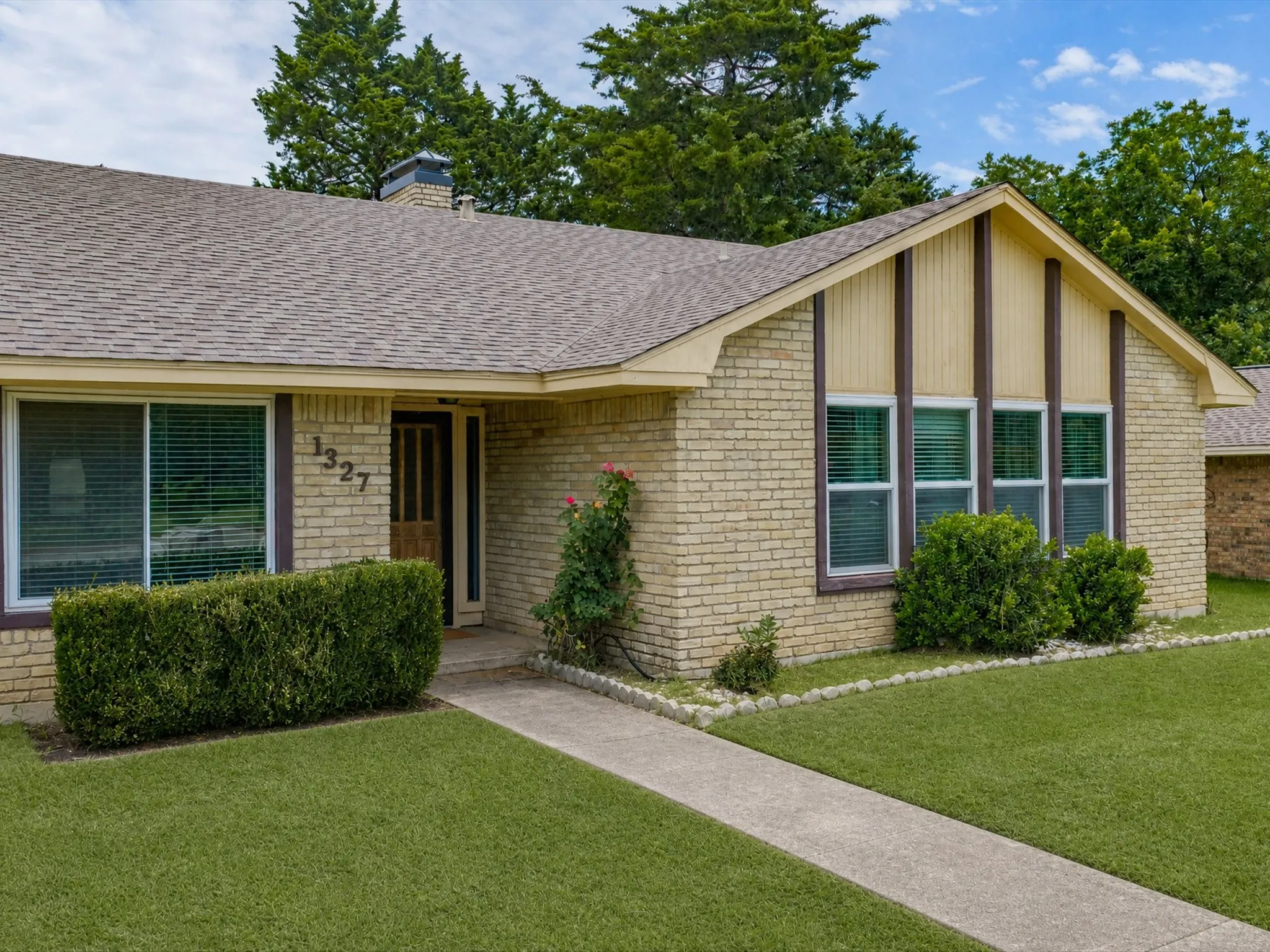Brick exterior featuring a gabled roofline and an exposed chimney