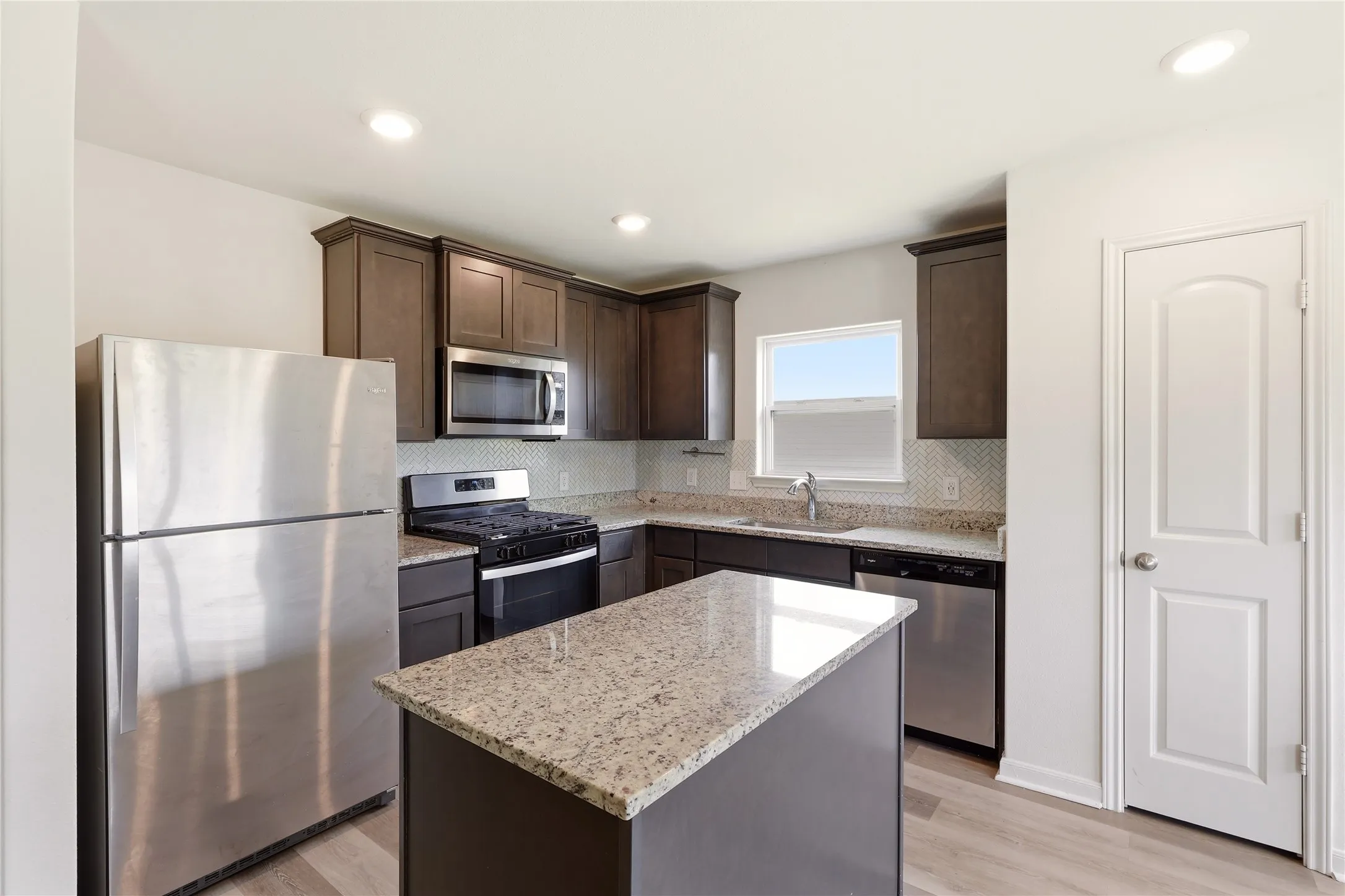 Kitchen with island and granite countertops.