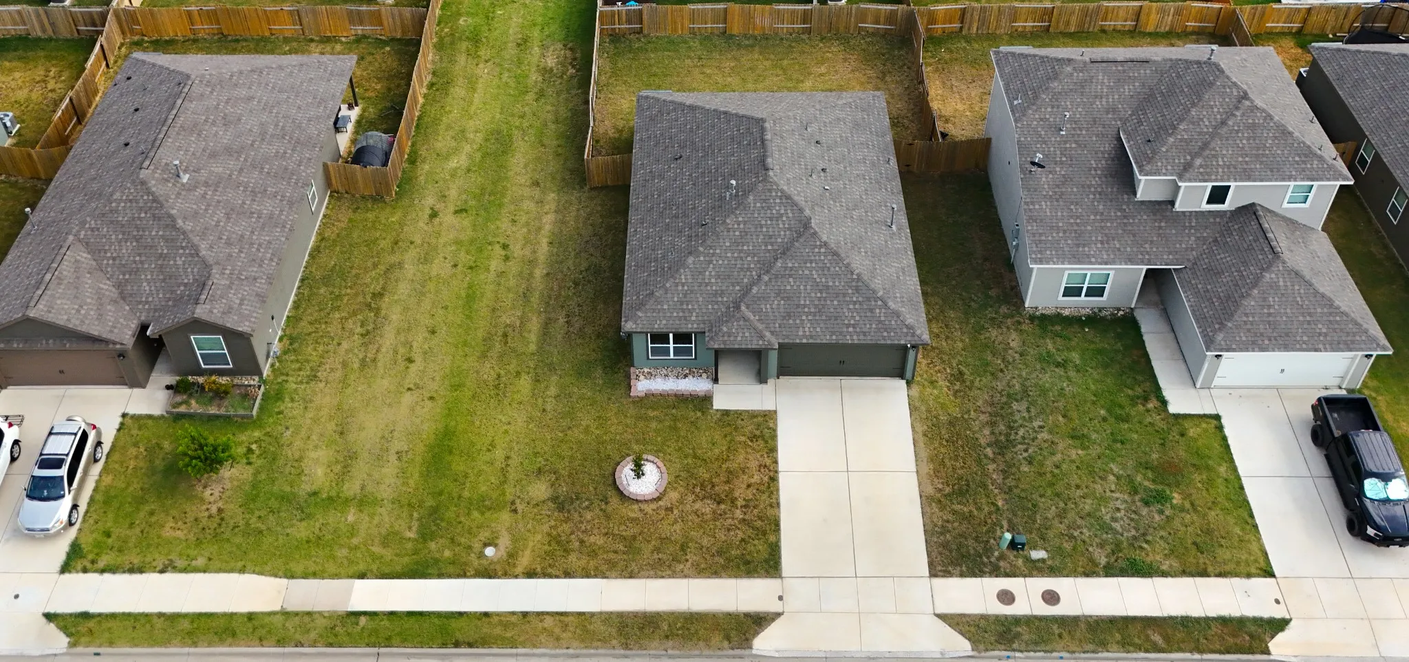 Aerial perspective showcasing the home's front yard and space to the side between homes.