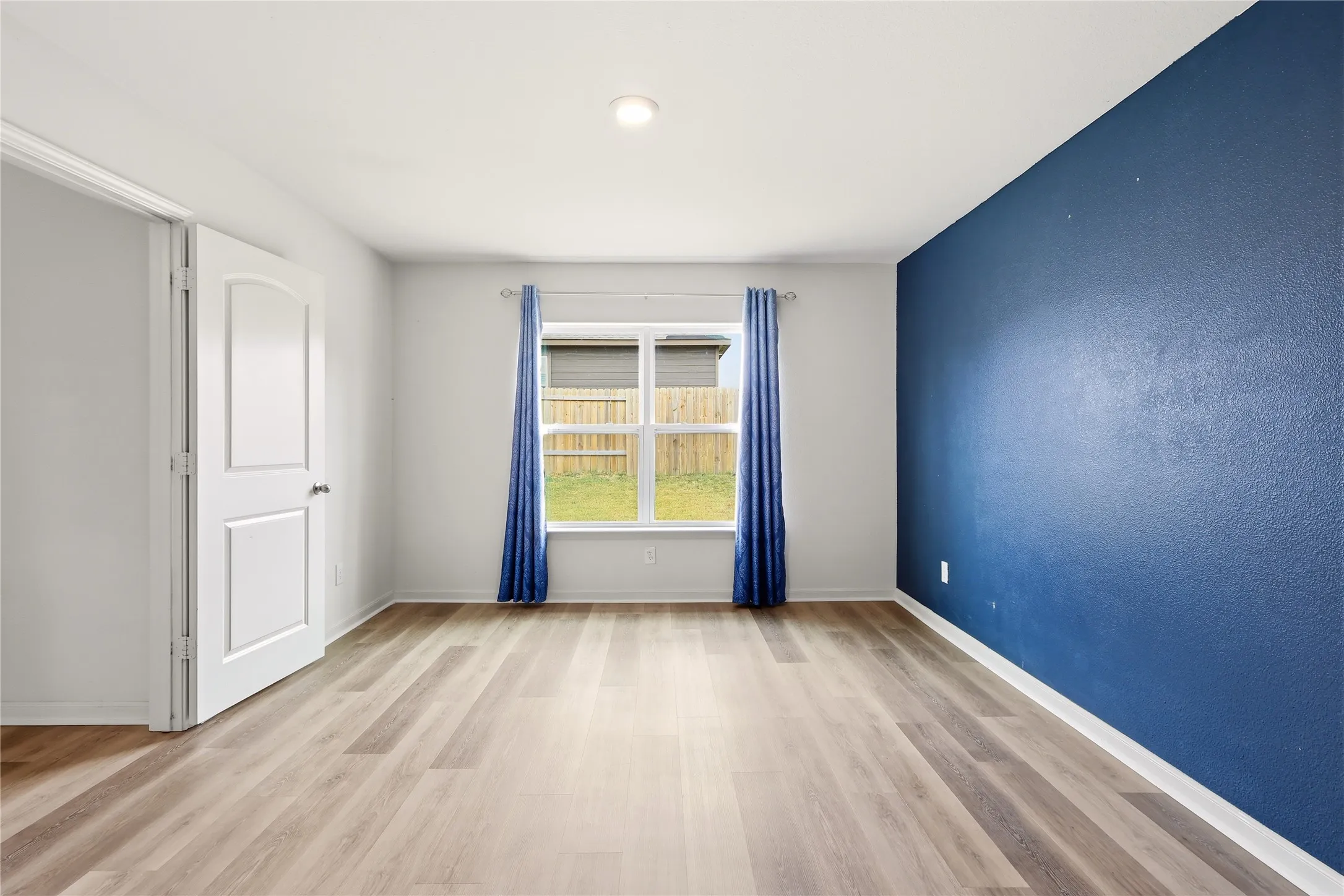 Primary Suite with windows looking out to the backyard.