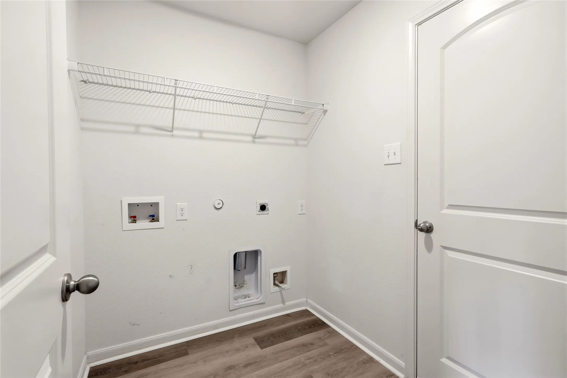 Dedicated laundry area featuring a wire storage shelf, and utility hookups.