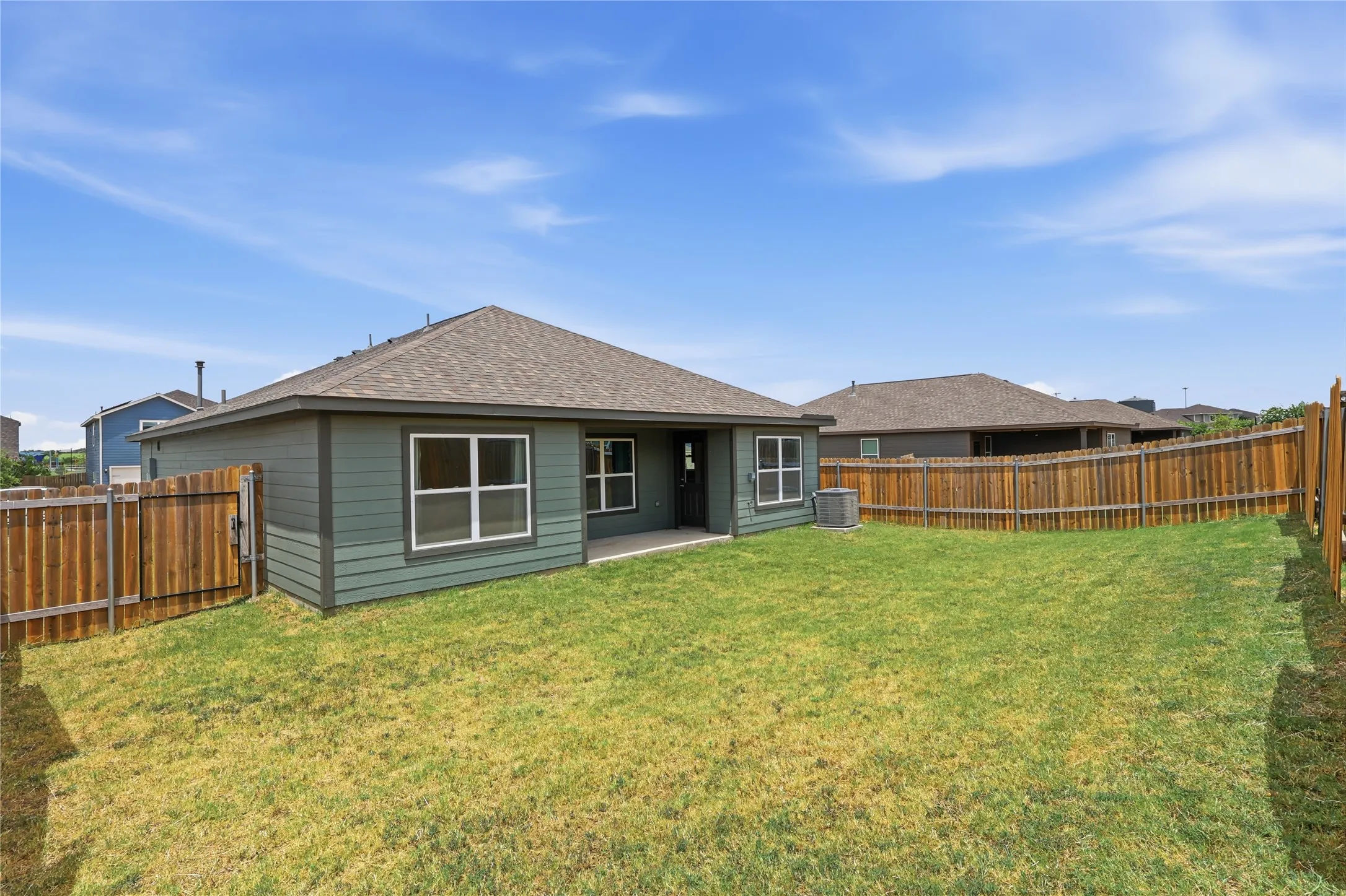 Backyard featuring a wood privacy fence and covered patio.