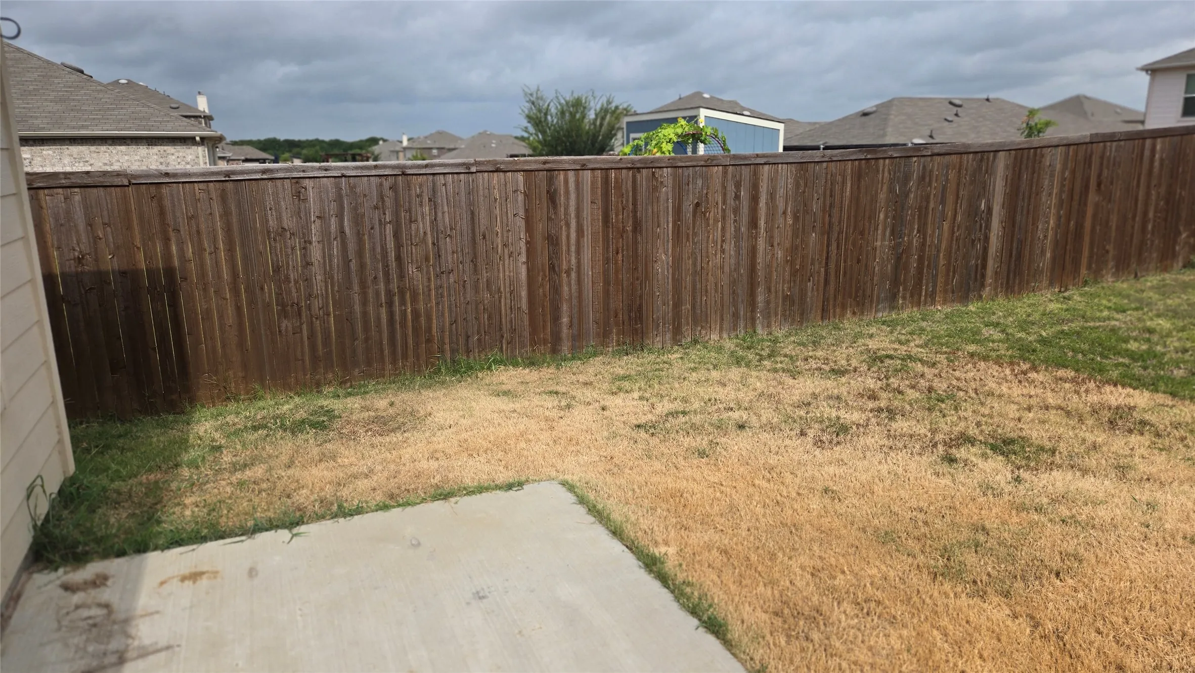 Fenced backyard featuring a concrete patio and a privacy fence