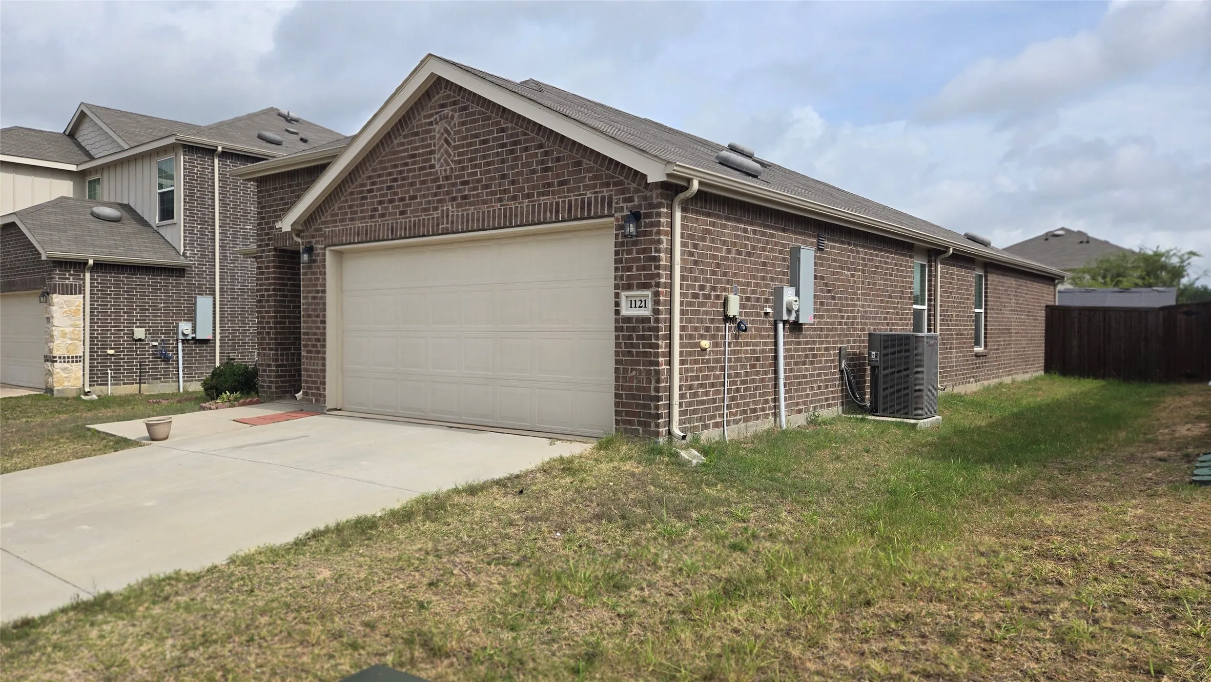 Brick exterior with a single-car garage and concrete driveway
