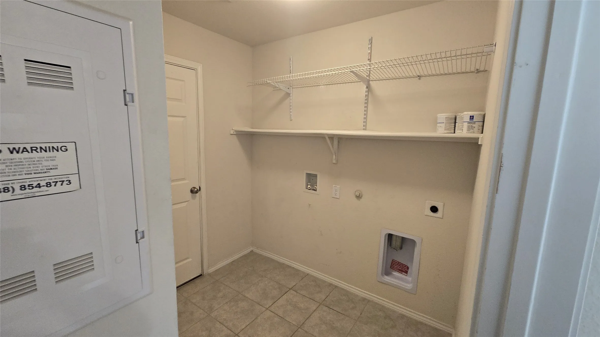 Dedicated laundry area featuring tile flooring and a neutral color palette