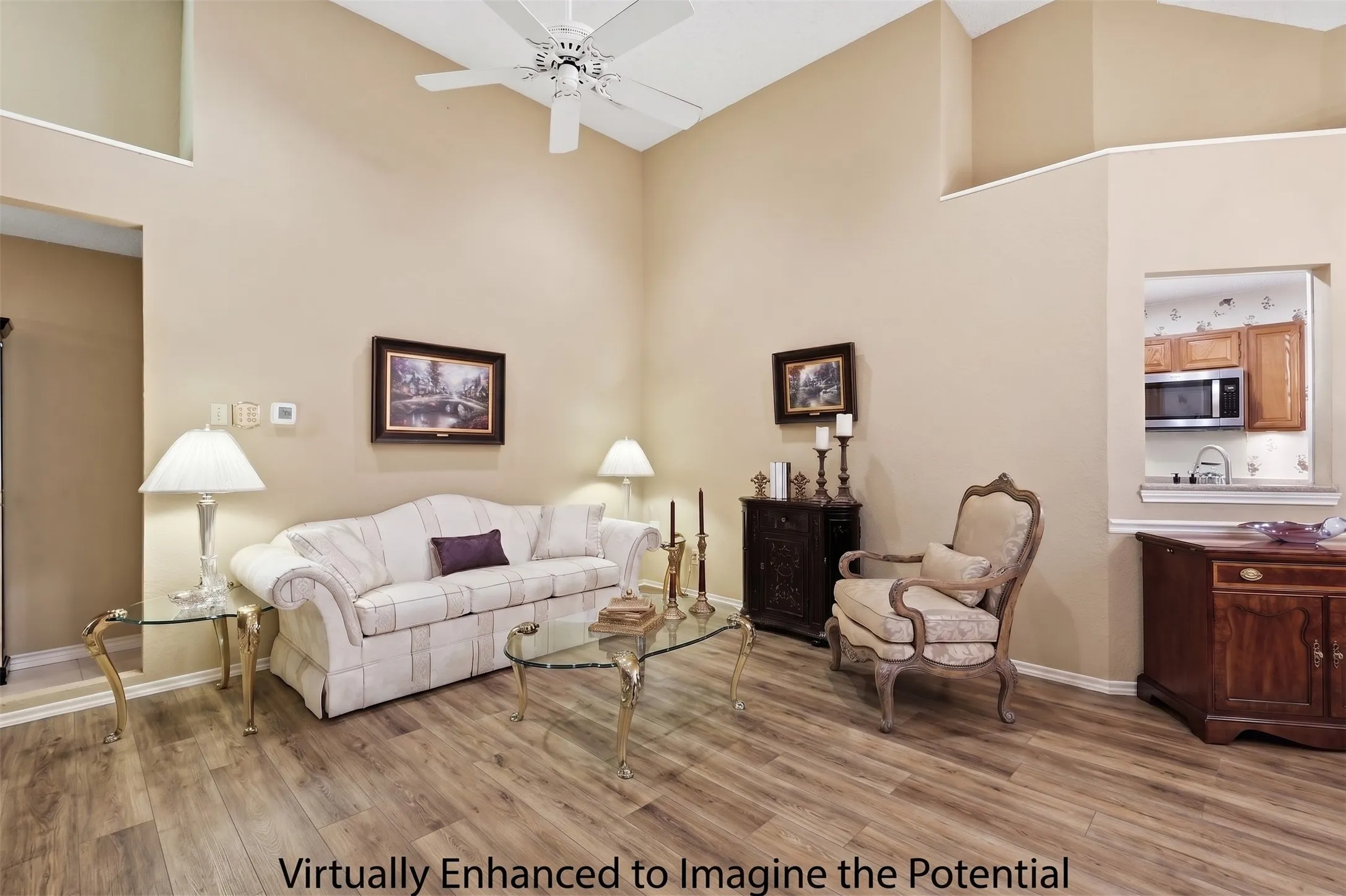 Vaulted ceiling with a ceiling fan, wood-finish flooring, and a pass-through window to the kitchen