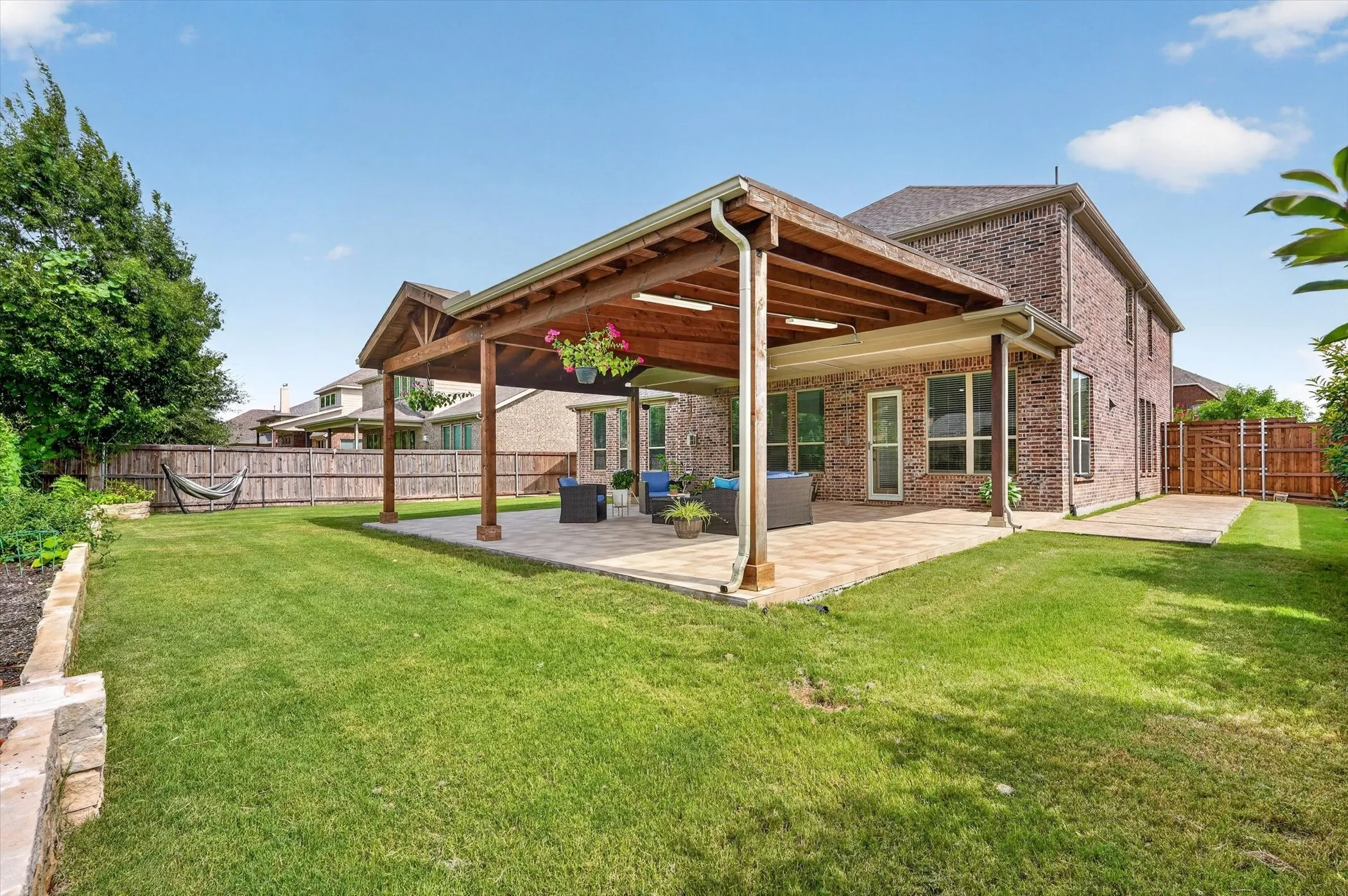 Lush yard with built it in garden beds, covered patio with electrical.
