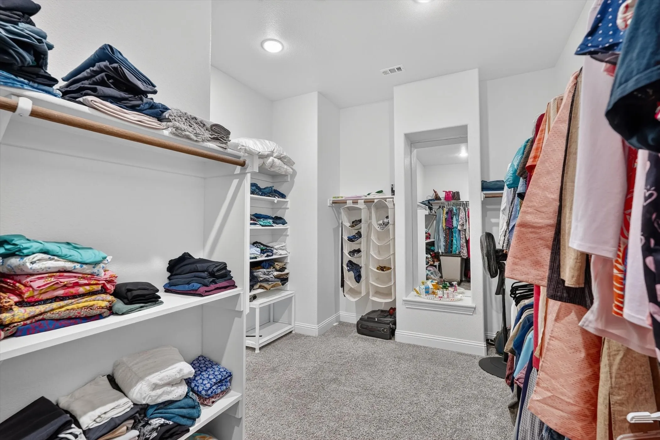 Primary closet with built in shelving.
