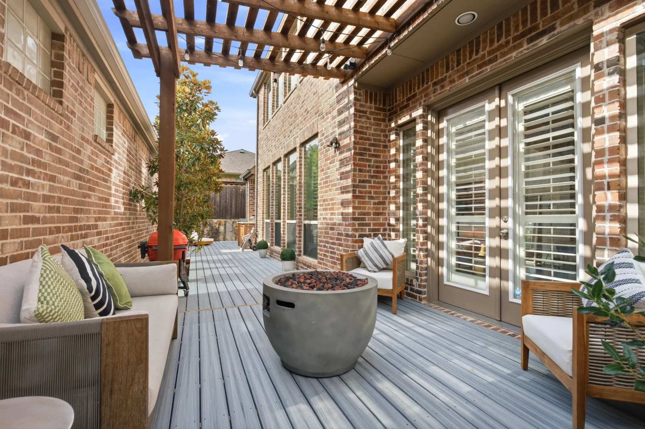 Easy-care, minimal maintenance is a cherished feature on this exceptional outdoor living space designed with entertaining in mind. A charming pergola-covered deck provides the perfect setting for relaxing in the shade or dining al fresco.