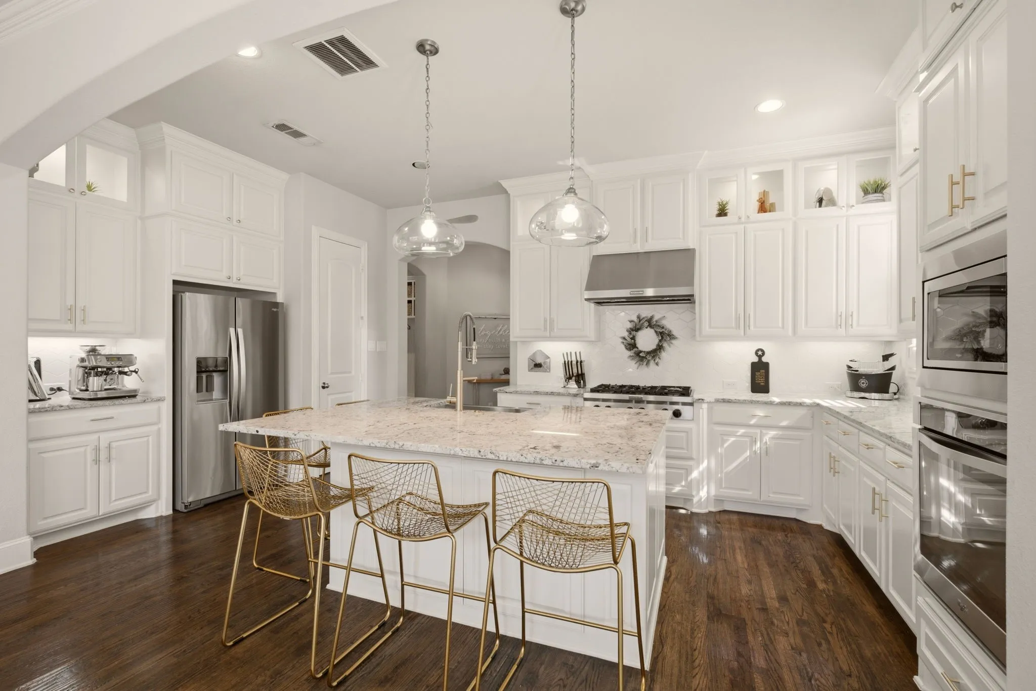 This photo epitomizes how great this kitchen is! Besides the crisp island pendants, note the left counter space---an ideal coffee or espresso bar + the left door leading to the deep walk-in pantry under the stairs. Just bring your own refrigerator.
