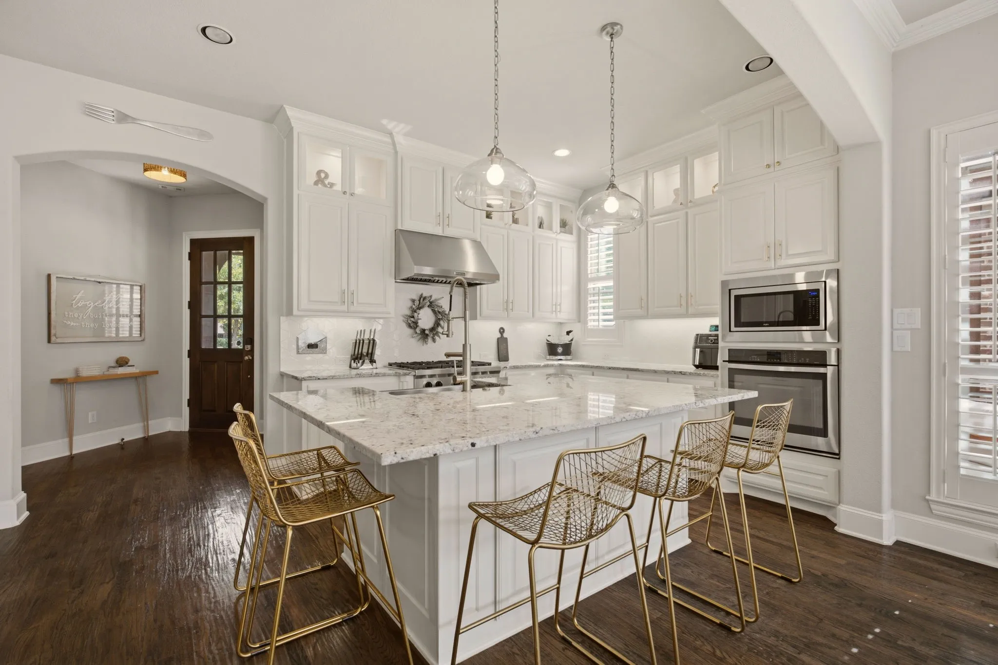 Another impressive standout ~  this striking, upgraded kitchen that's designed for those who demand functionality combined with an seamless flow to the living & dining areas. A reconfigured-enlarged island offers more storage from the floor-to-ceiling cabinets + a nearby walk-in pantry.