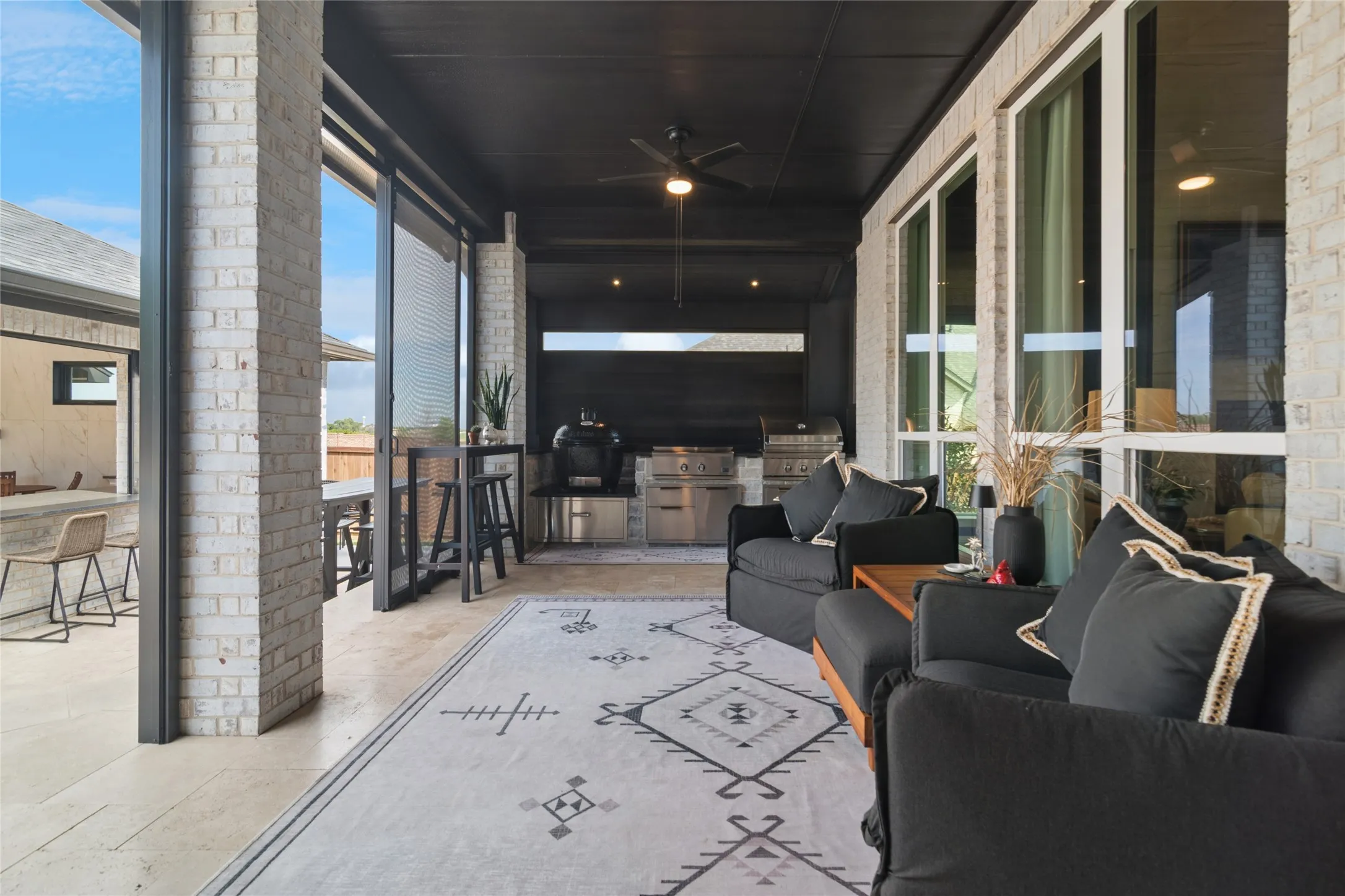 Covered screened in porch off of dining area, kitchen, main living area. Fantastic cooking area at the end of the room with large Primo Smoker, DCS Griddle and DCS Grill.