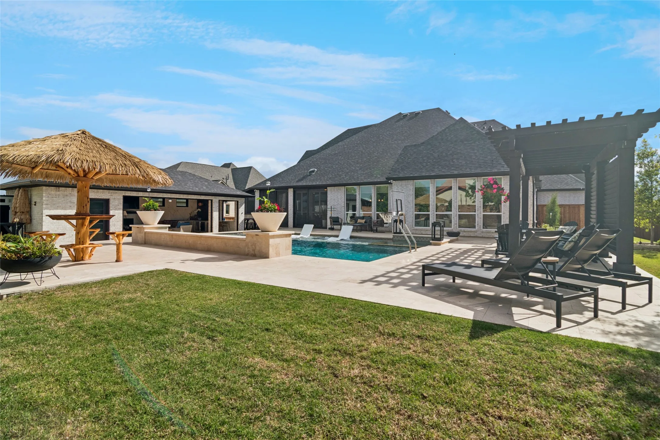 Beautifully manicured grass and landscaping. Extra travertine decking for room to relax and move around the pool comfortably.