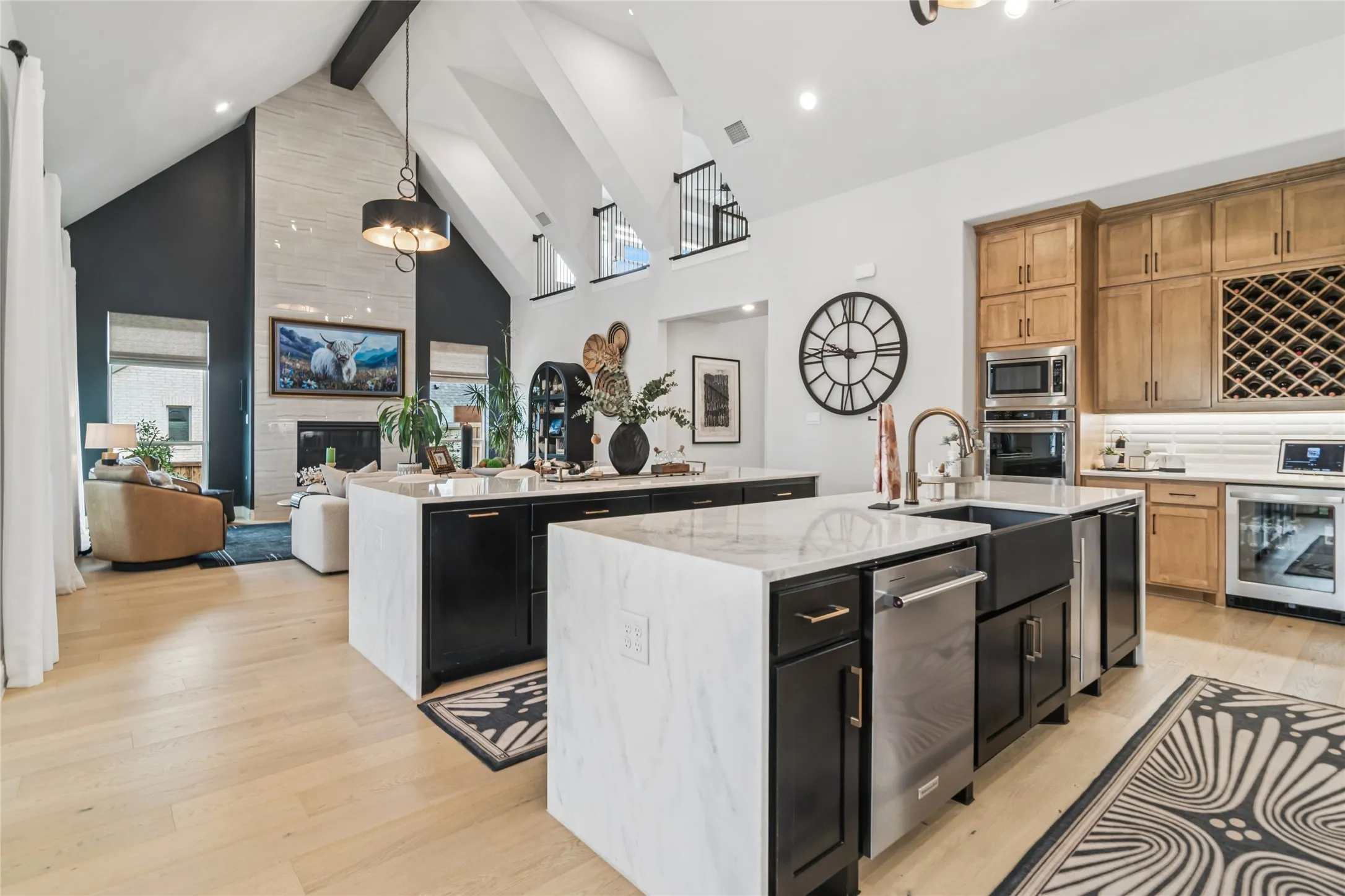 2 oversized islands with waterfall granite, both allow for bar seating. Dual pullout garbage cans, ice maker, apron front large single sink, beverage frig at drink bar with wine storage above. Double oven.