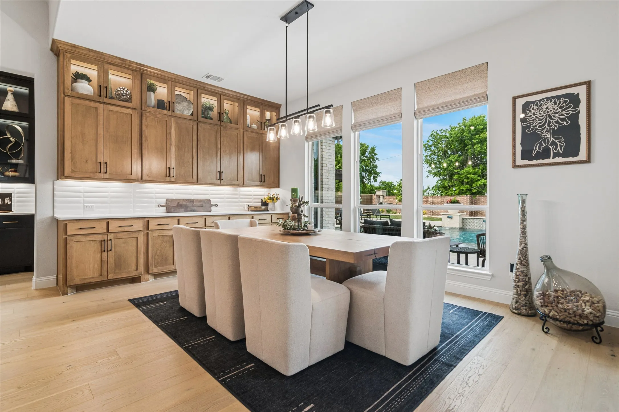 Beautiful bank of cabinets with long counter top next to the dining area. Windows overlook backyard and pool.