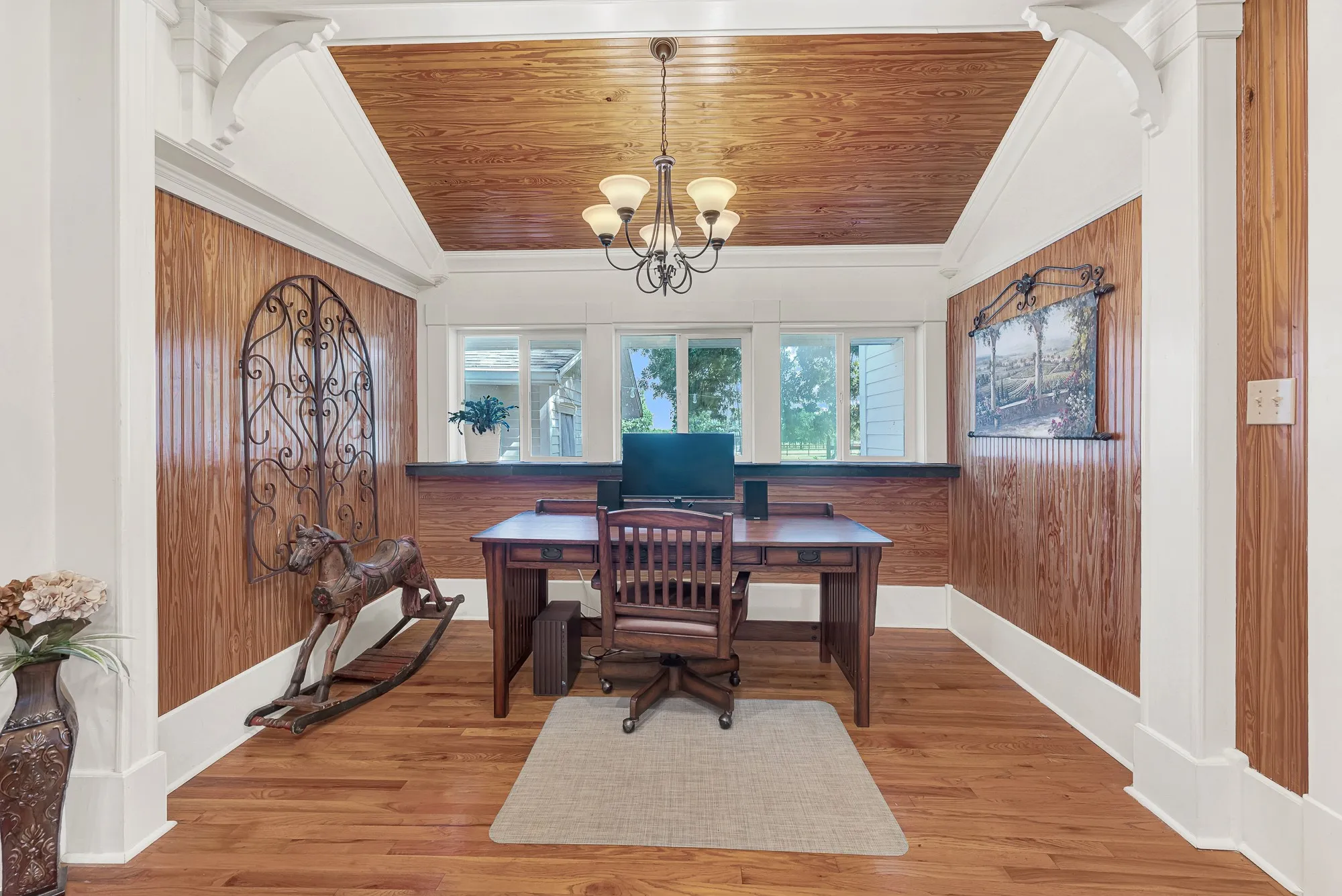Sunlight pours through a wall of windows, while warm wood accents and detailed trim give this office a comfortable, timeless feel. It's an inspiring place to work during the day, then close the laptop and enjoy the peaceful views beyond the glass.