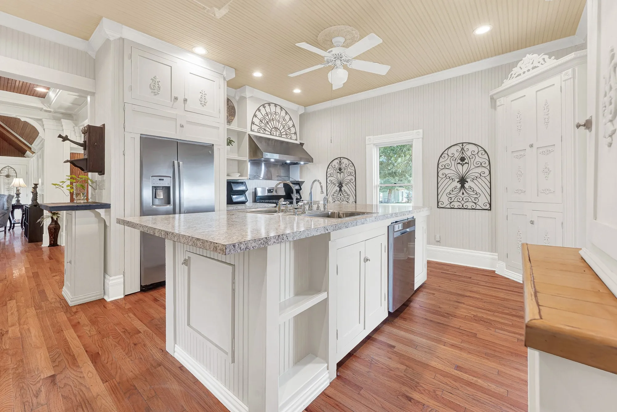 The oversized island anchors the kitchen beneath soaring beadboard ceilings, creating an open workspace filled with natural light and timeless character. Picture everyone gathering here over pancakes and coffee before heading out to enjoy the property's wide-open spaces.