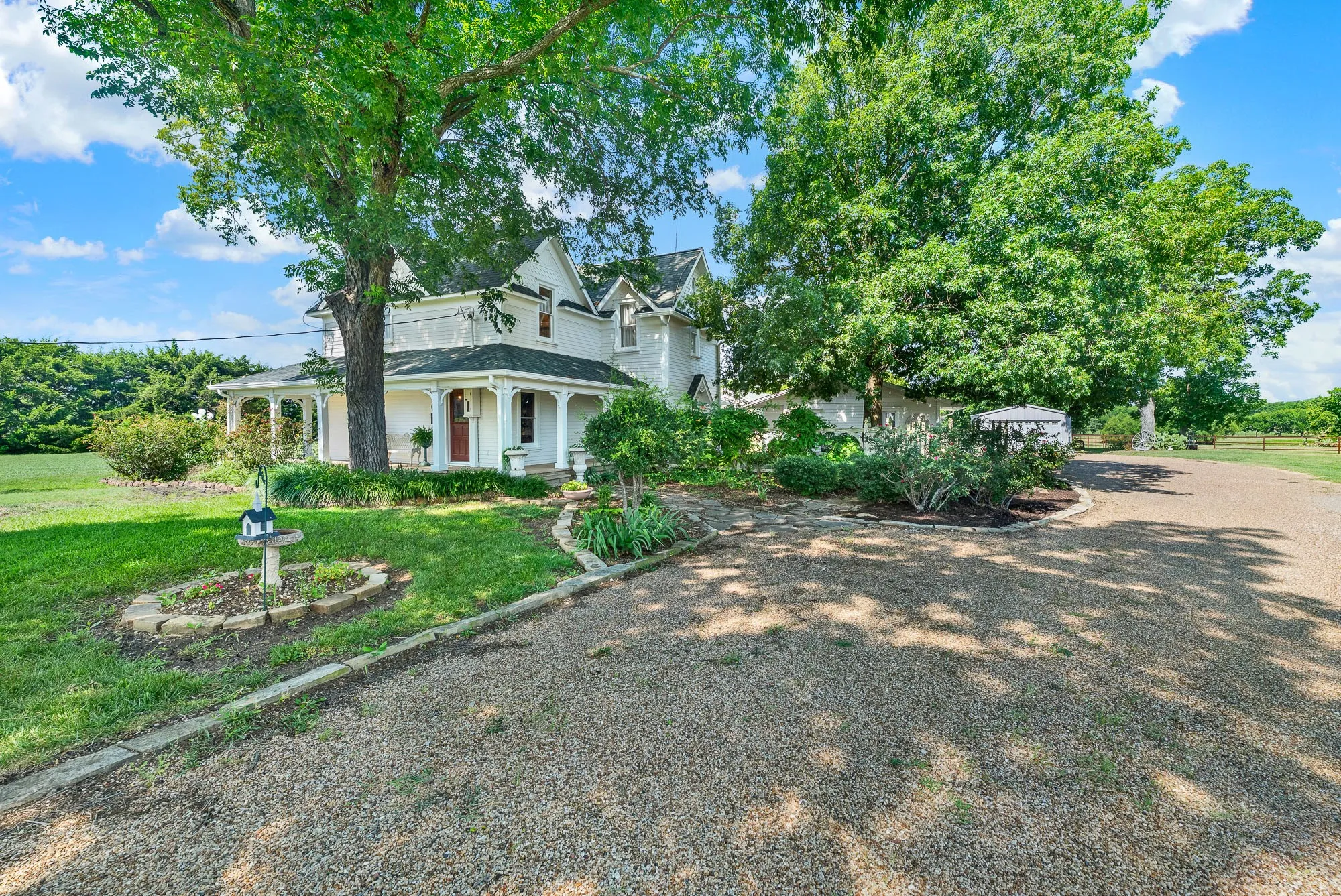 The expansive gravel driveway provides exceptional off-street parking, easily accommodating residents, tenants, and guests. Towering shade trees and beautifully landscaped grounds create a memorable arrival while offering convenient access to every area of this unique 2.44-acre estate.