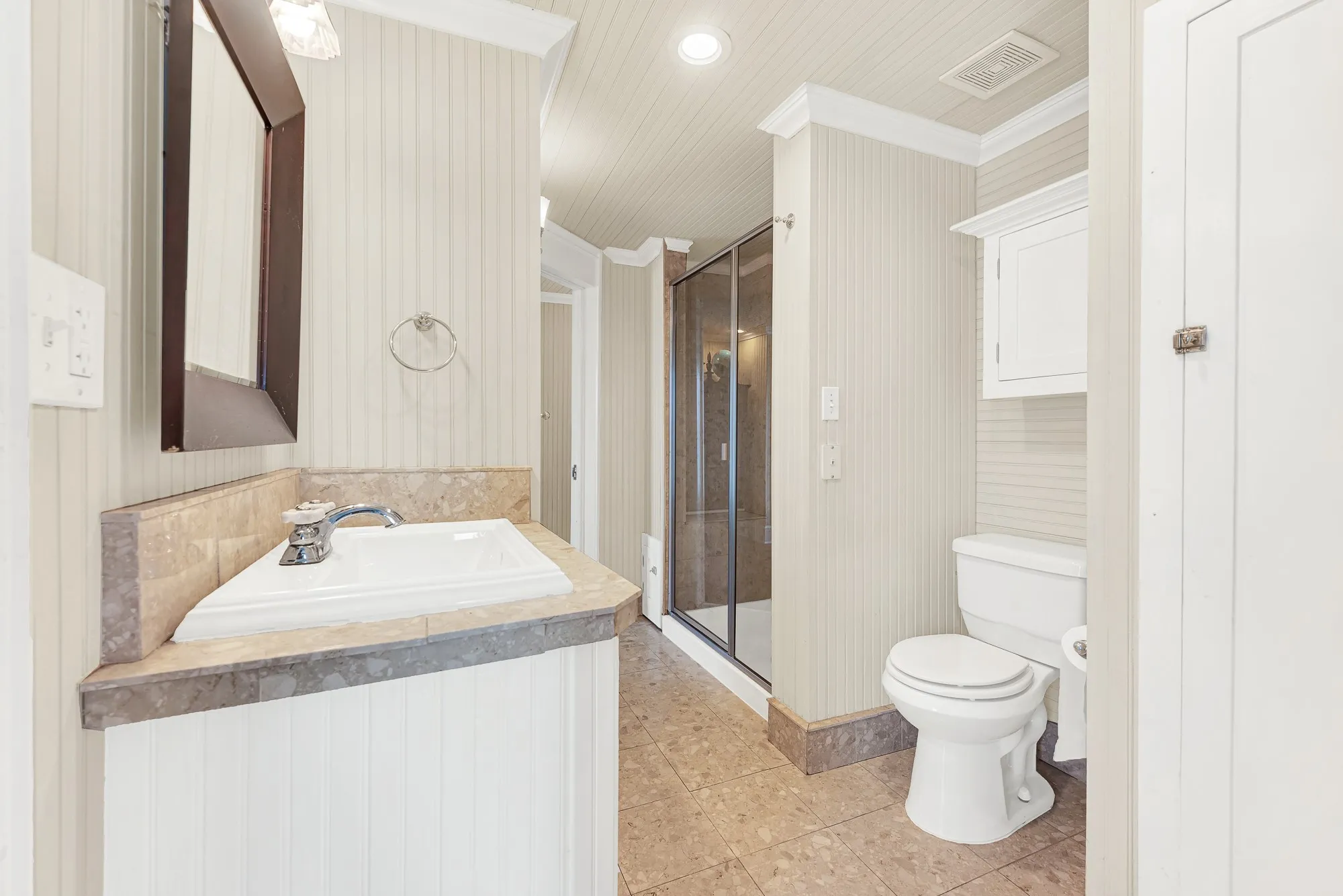 Natural stone countertops and a spacious layout create a bathroom that's both timeless and designed for everyday convenience. The Jack-and-Jill arrangement gives adjoining bedrooms easy access while providing comfort and privacy for family or overnight guests.