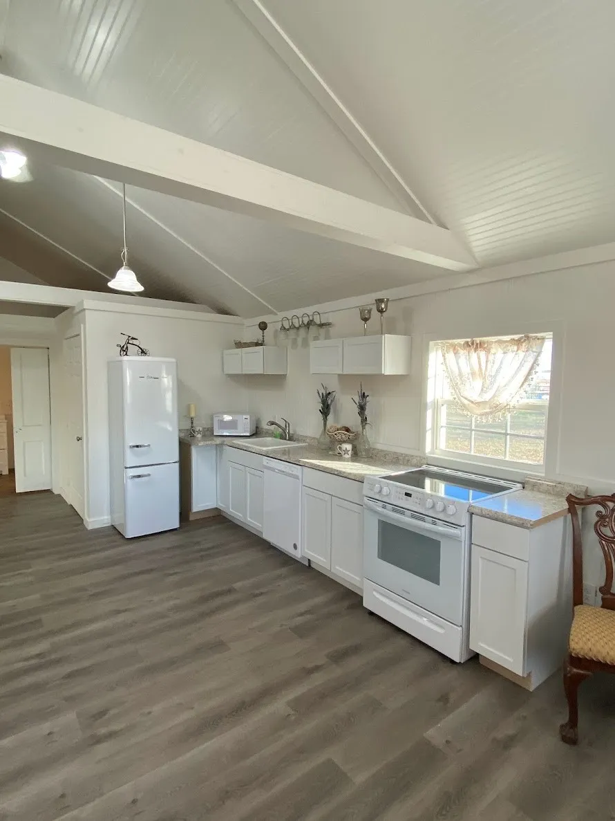 Cottage C - Exposed beams and vaulted ceilings add architectural character, while oversized windows fill the home with natural light throughout the day. The bright, open layout creates a comfortable space that appeals to tenants and makes this cottage a valuable income-producing asset.