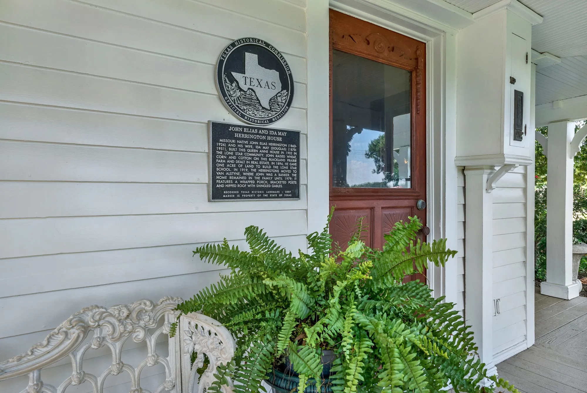 A designated Texas Historic Landmark, the John Elias and Ida May Herrington House is recognized for its historical significance and enduring craftsmanship. The official historical marker highlights the home's rich heritage, while the welcoming front porch and original entry door offer a glimpse into the property's timeless character and well-preserved architectural details.