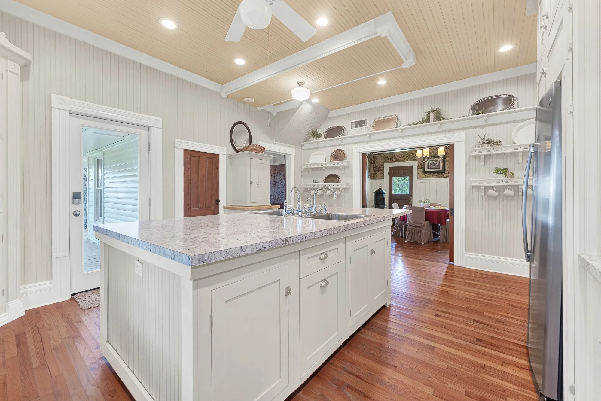 The expansive island with double sinks anchors a 2022 kitchen remodel featuring updated countertops, oven, refrigerator, and dishwasher, all thoughtfully integrated into the home's Victorian character. Whether baking with grandchildren or serving a crowd during the holidays, this kitchen was made to bring people together.
