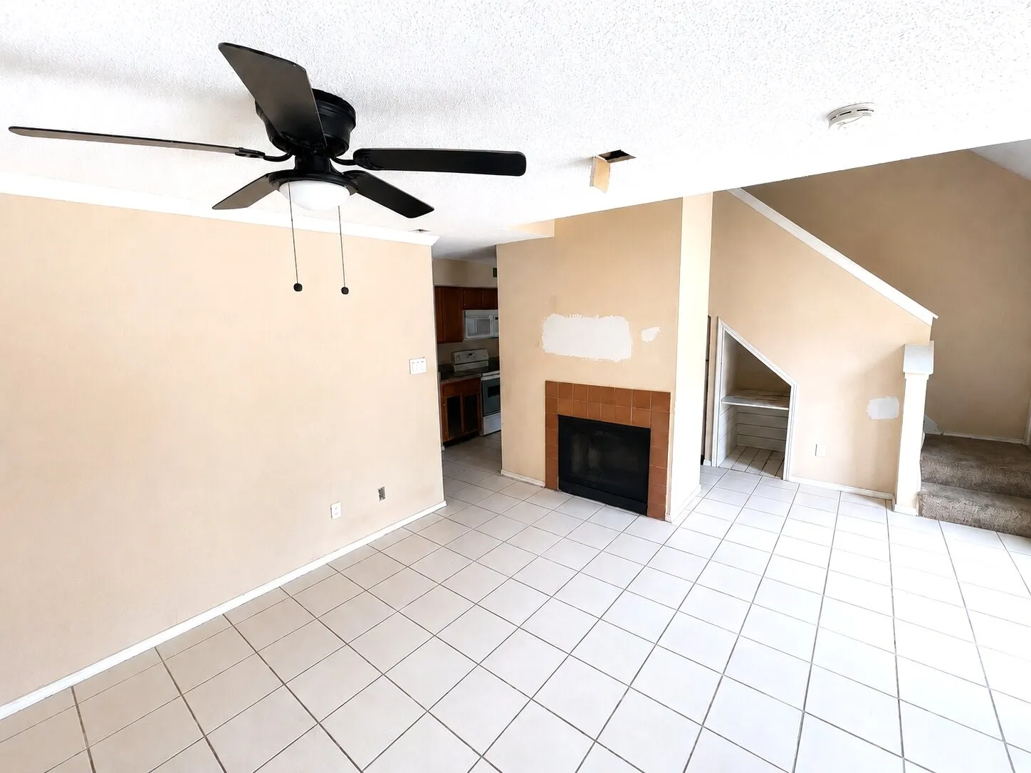 Living area featuring white tile flooring and a ceiling fan