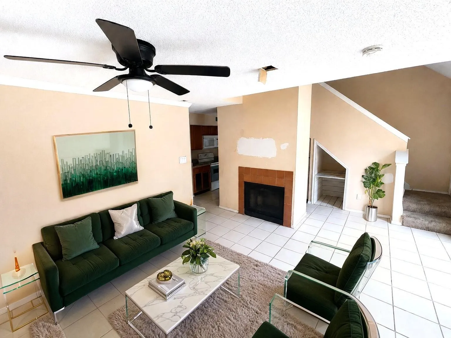 Virtually staged
Living space featuring a prominent fireplace with a tile surround, white tile flooring, and a ceiling fan with integrated lighting