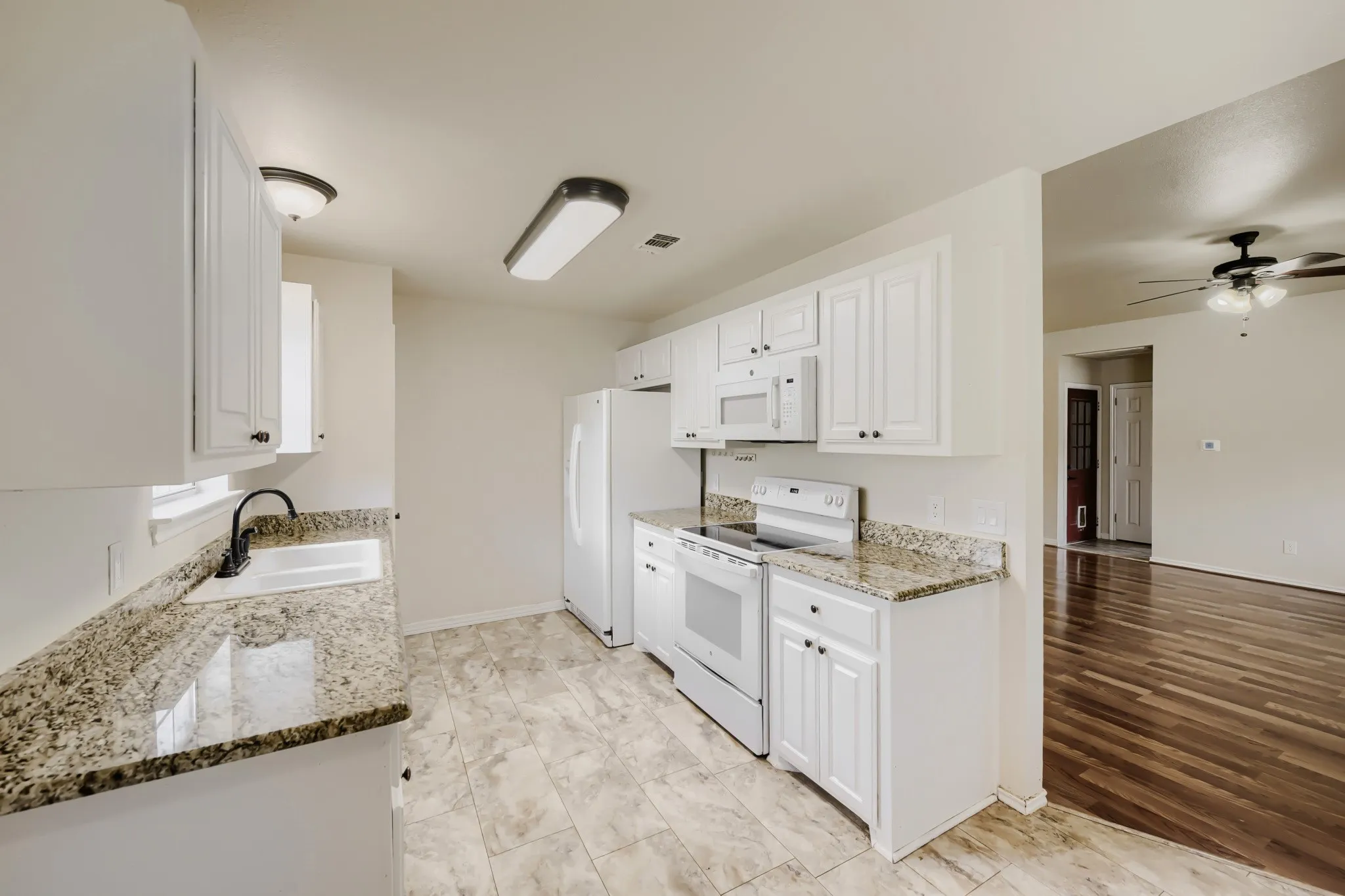 Kitchen featuring white cabinetry, granite countertops, white appliances, and tiled flooring