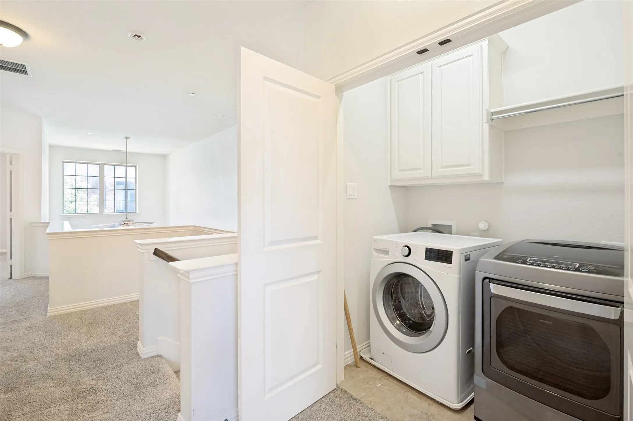 Dedicated laundry area featuring upper cabinetry, a built-in shelf, and recessed lighting