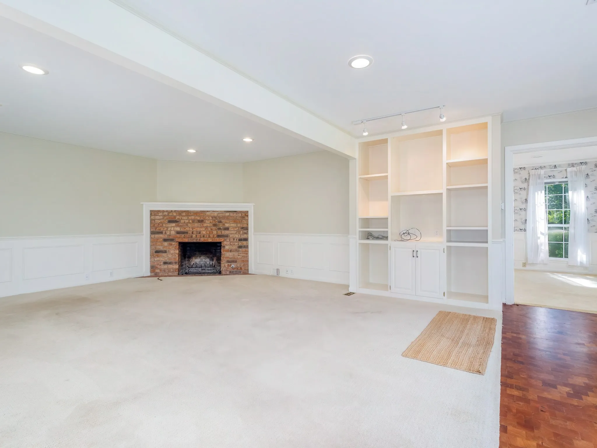 One of two gas fireplaces with bookshelves and cabinets. Carpet and mesquite parquet floor