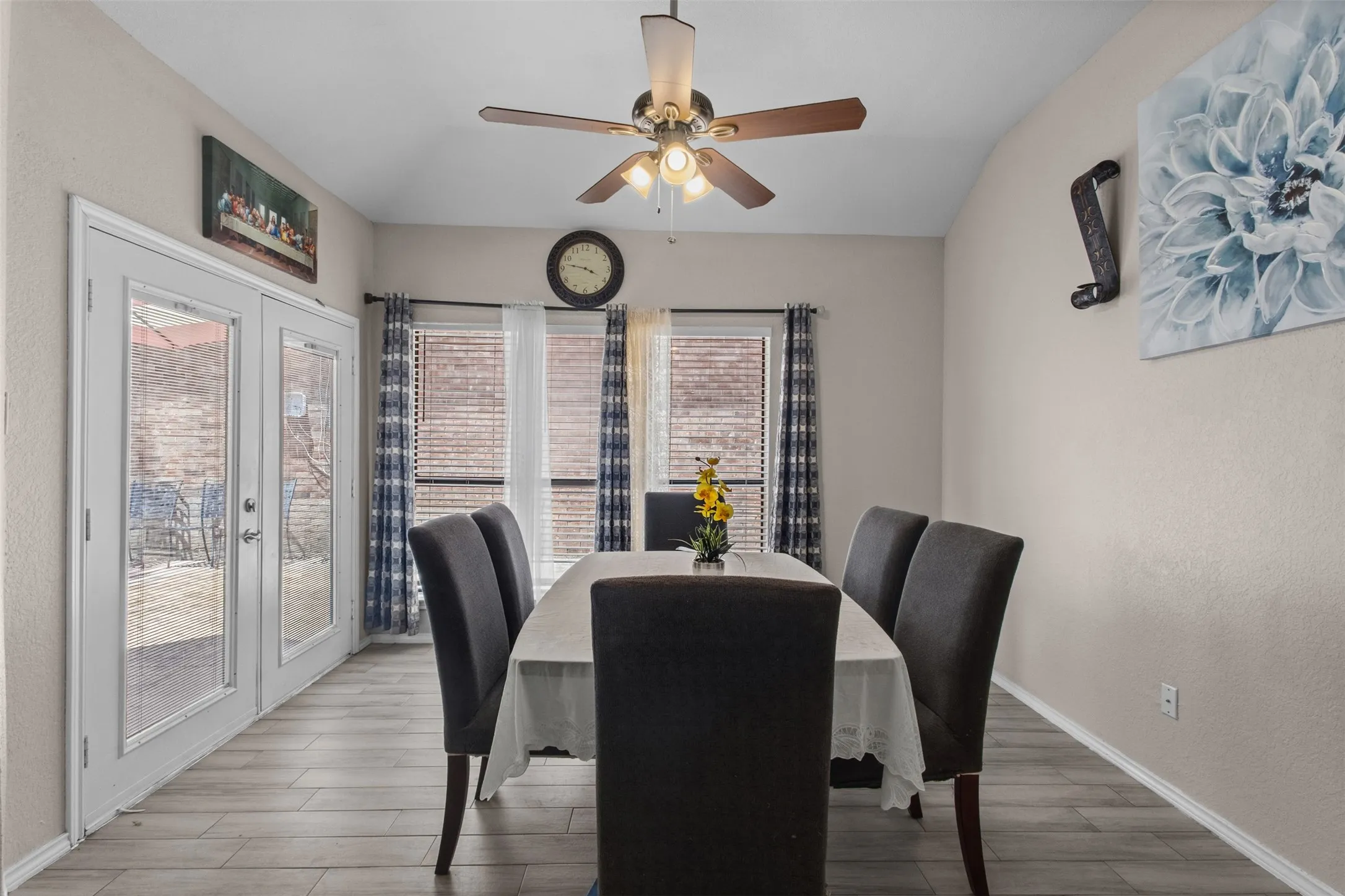 Spacious dining area featuring wood-finish flooring and a vaulted ceiling with a ceiling fan