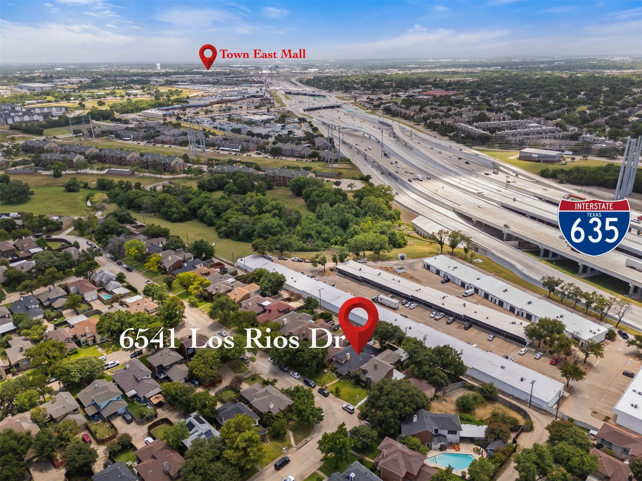 Aerial overview showcasing a residential neighborhood with established homes and mature trees