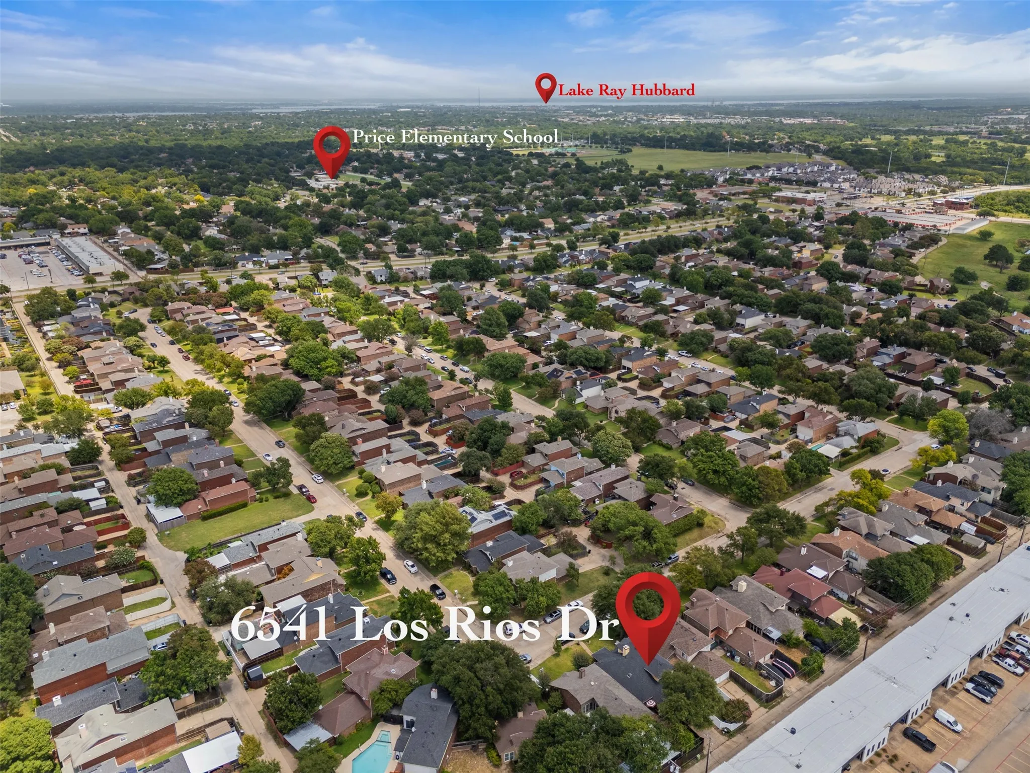Aerial perspective of a developed residential area featuring numerous single-story homes with varied rooflines and mature tree coverage