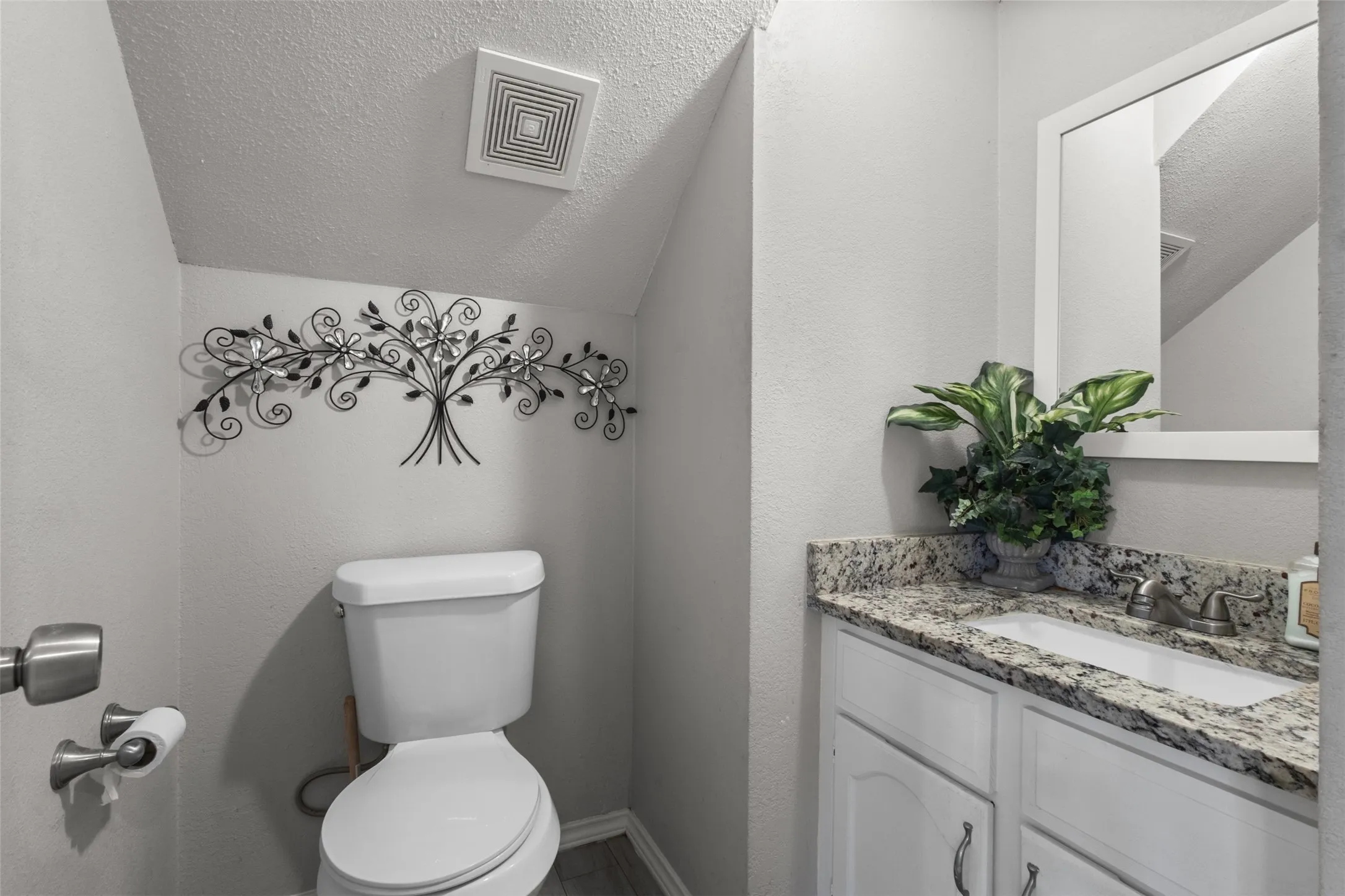 Vanity featuring a granite-finish countertop with an undermount sink and a framed mirror