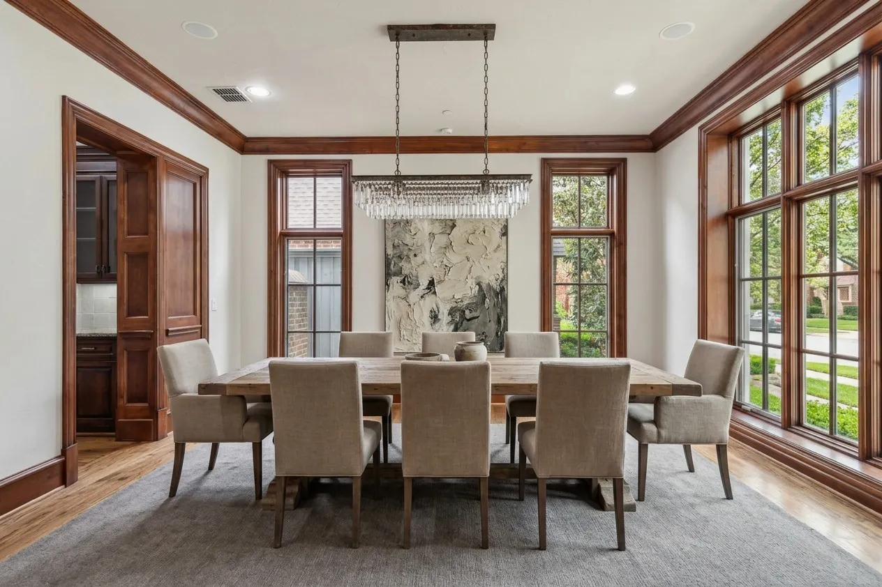 Hardwood flooring, extensive wood trim detailing, recessed lighting, chandelier, and a large window array