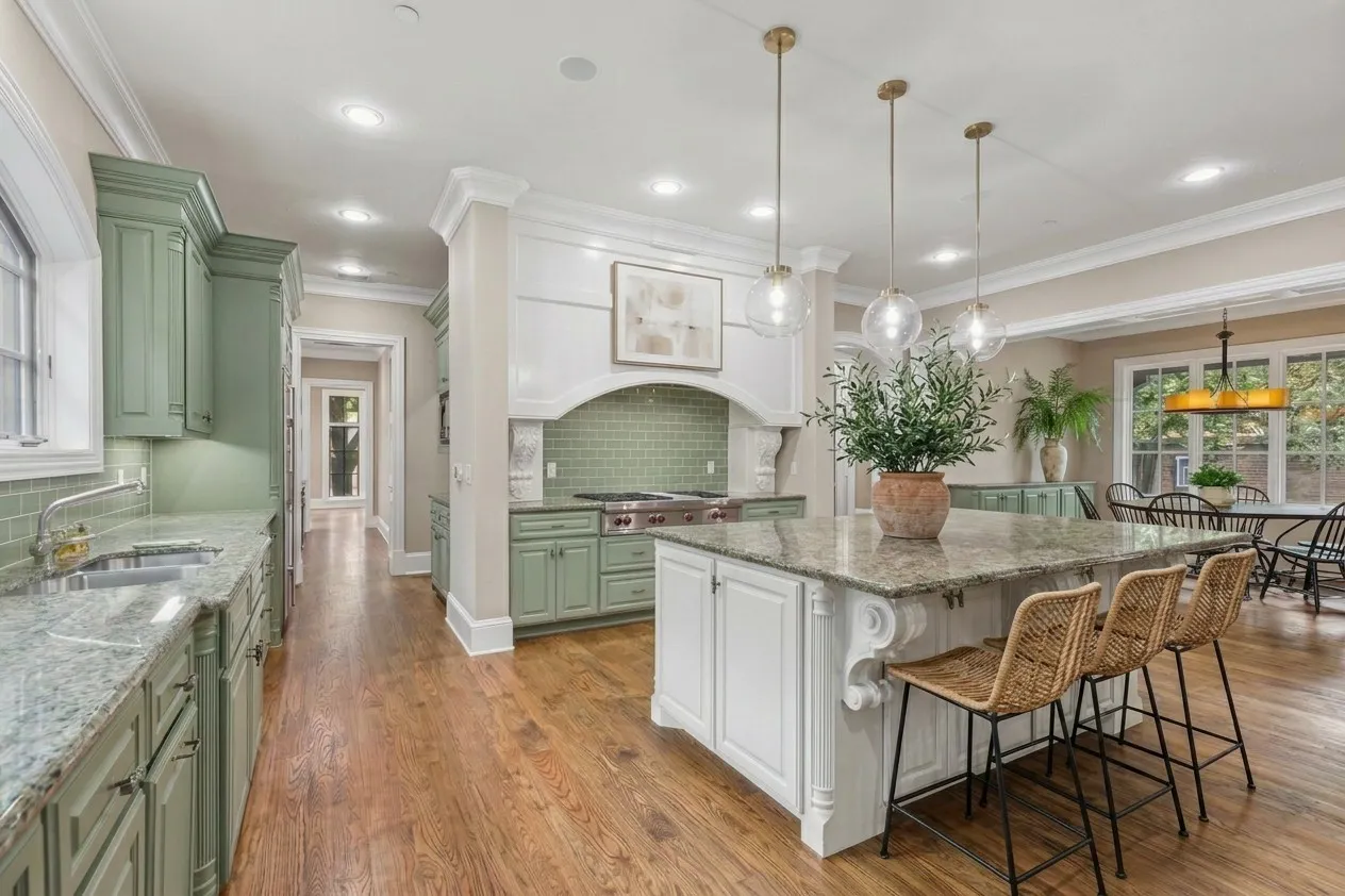 AI PAINTED Spacious kitchen featuring an expansive center island, warm wood-finish flooring, recessed lighting, and elegant pendant fixtures