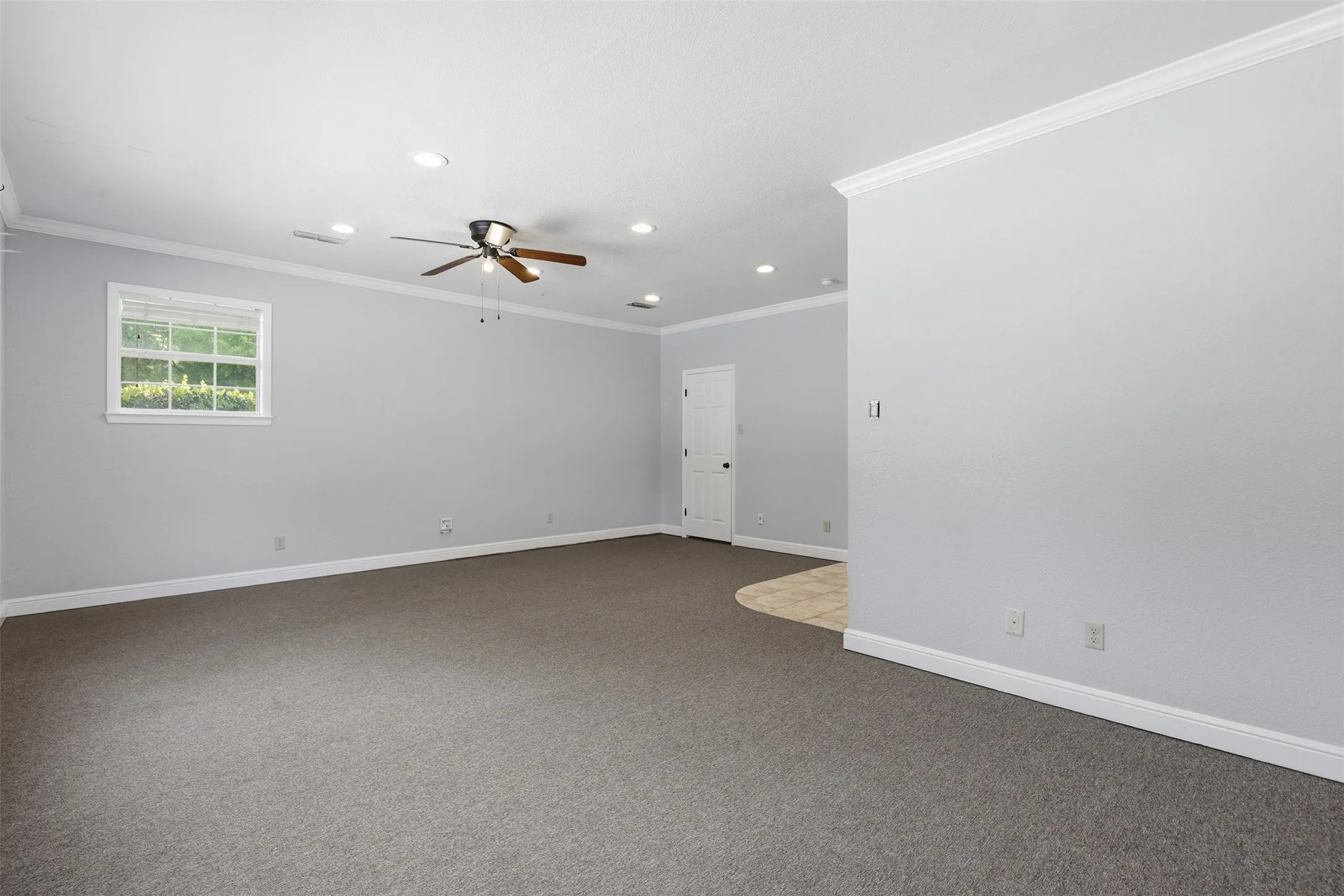 Spacious room featuring neutral gray carpeting and light gray walls