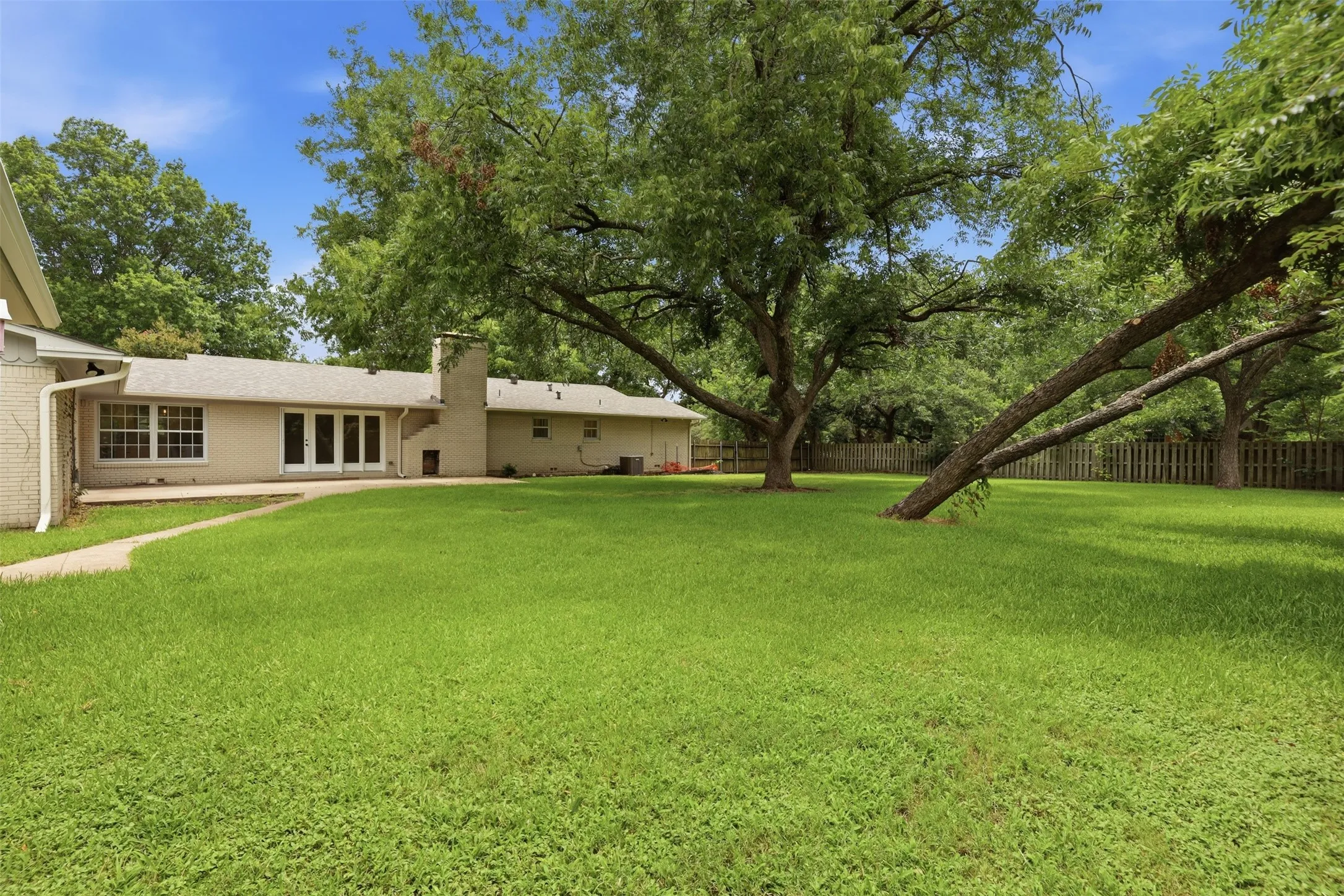 Expansive backyard with a large grass lawn and mature trees