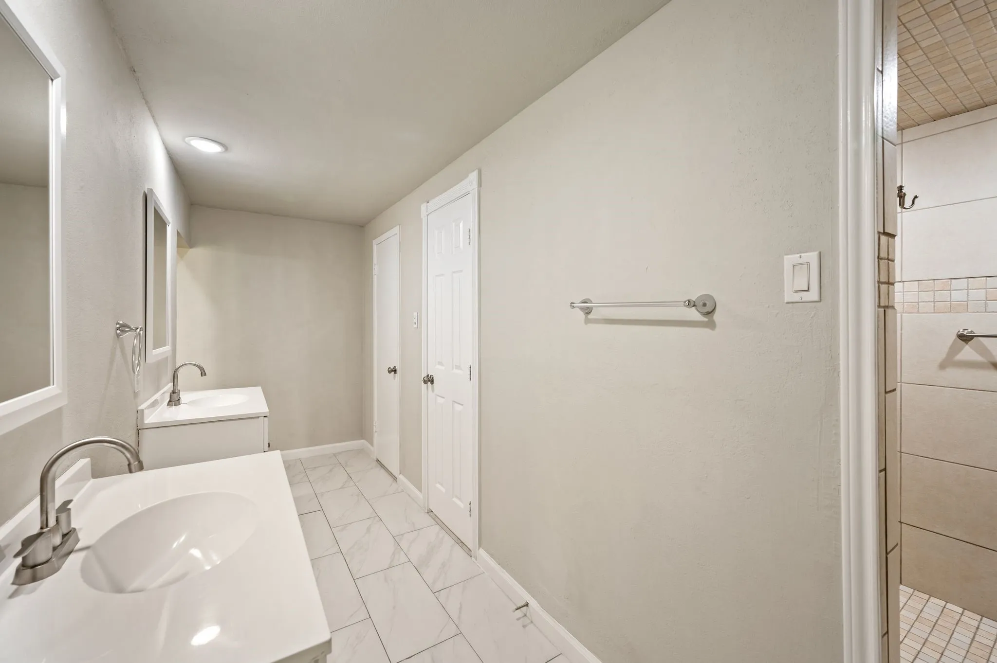 Dual sink vanities in Primary Suite; Shower is a GIGANTIC Walk-in with seating; Door far right is a massive walk-in closet; Door in middle is the private water-closet with updated commode