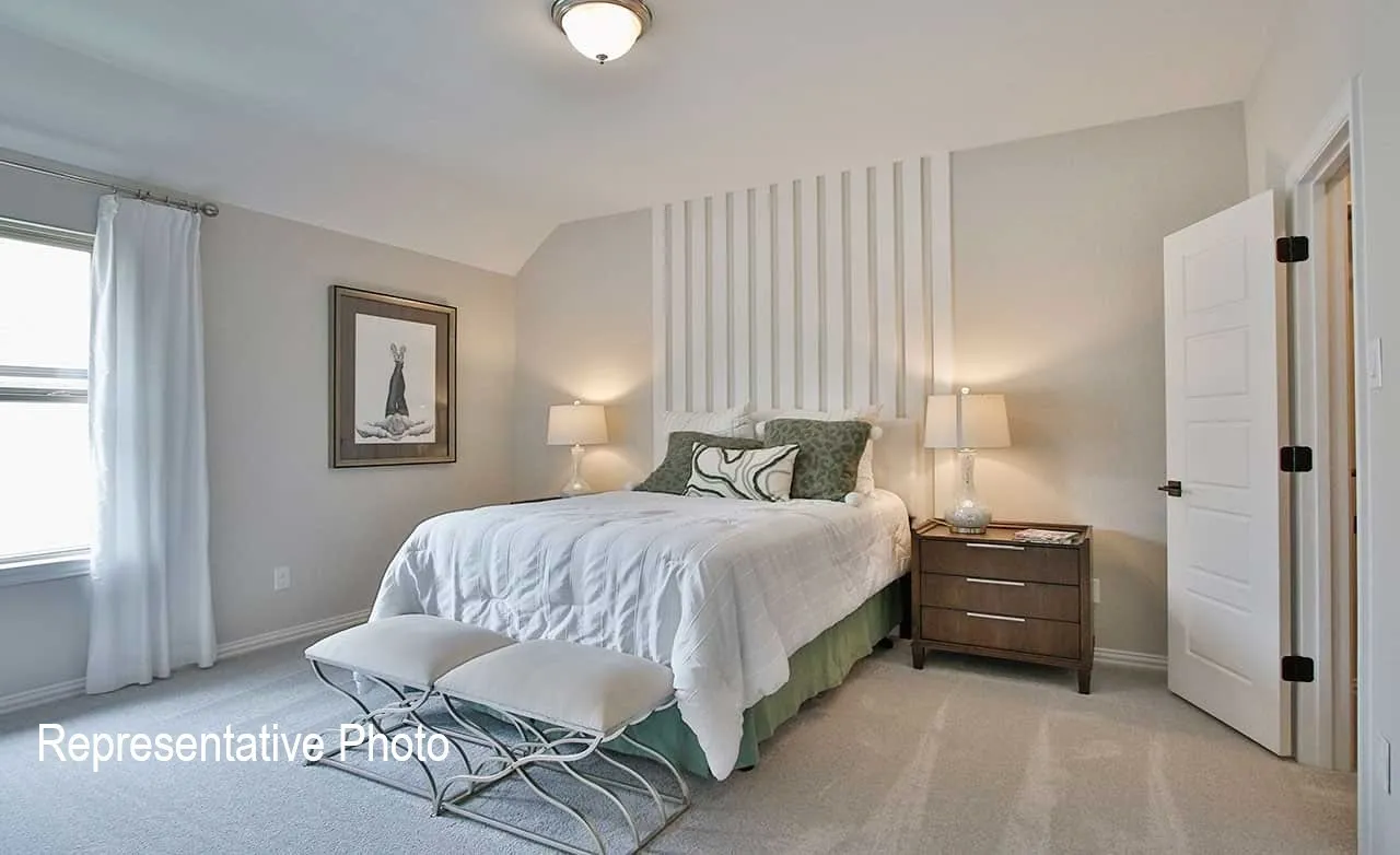 Carpeted room featuring a window with natural light, a decorative wall panel, a ceiling-mounted light fixture, and an interior panel door
