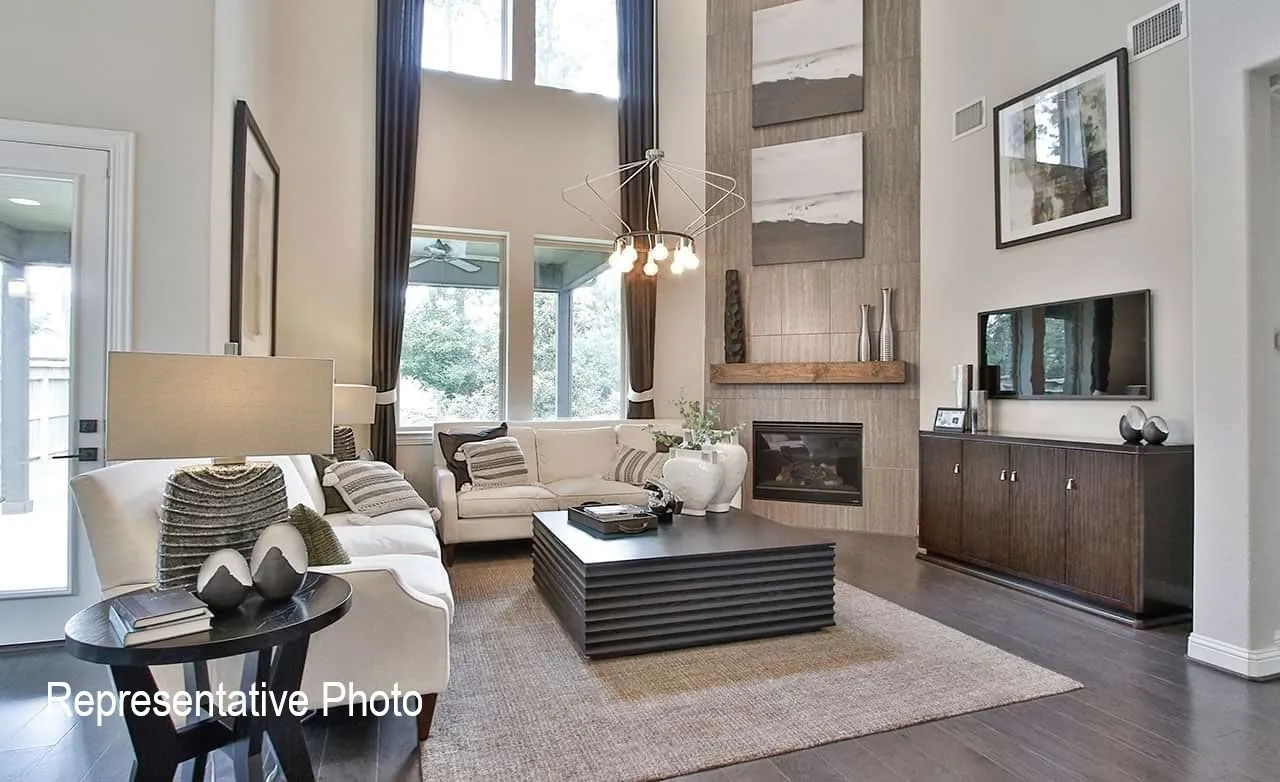 Living area featuring high ceilings, dark wood-finish flooring, a contemporary fireplace with a wood mantel, and large windows